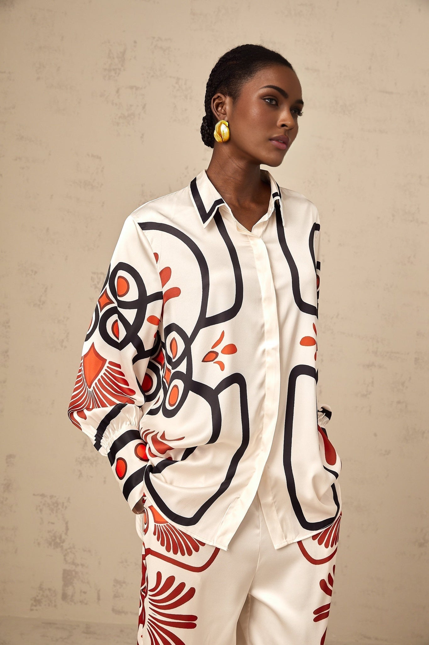 Woman wearing matching shirt and trousers set with colorful graphic print pattern