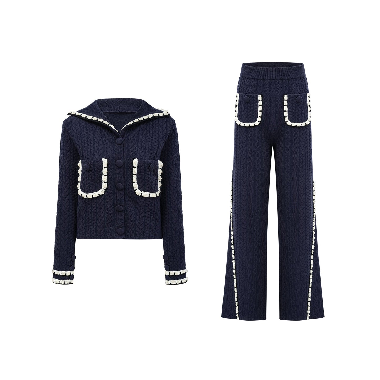 Woman wearing navy blue crochet knit cardigan and matching trousers standing against plain background