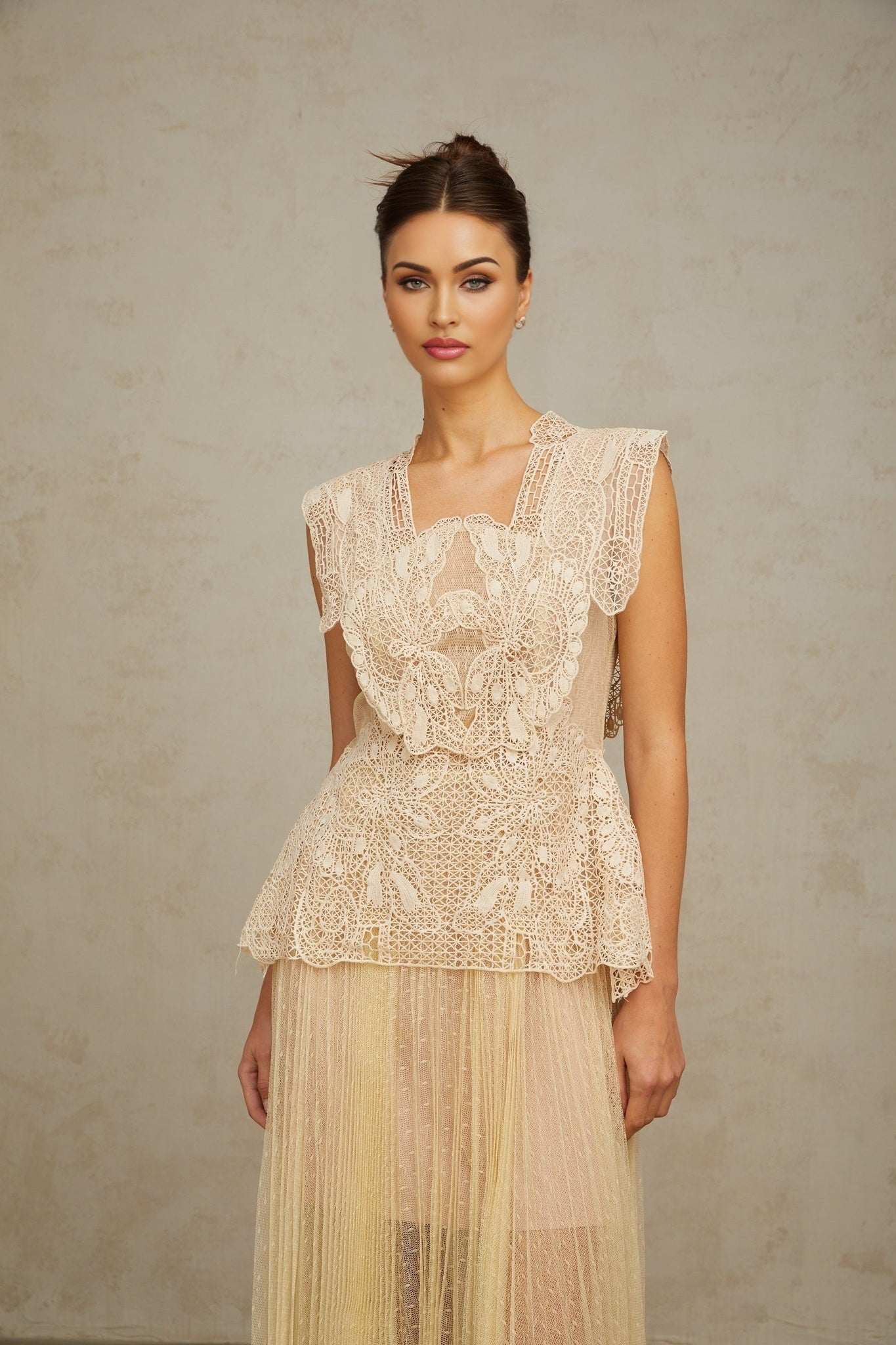 Woman wearing neutral colored midi dress with floral lace panels and tulle skirt