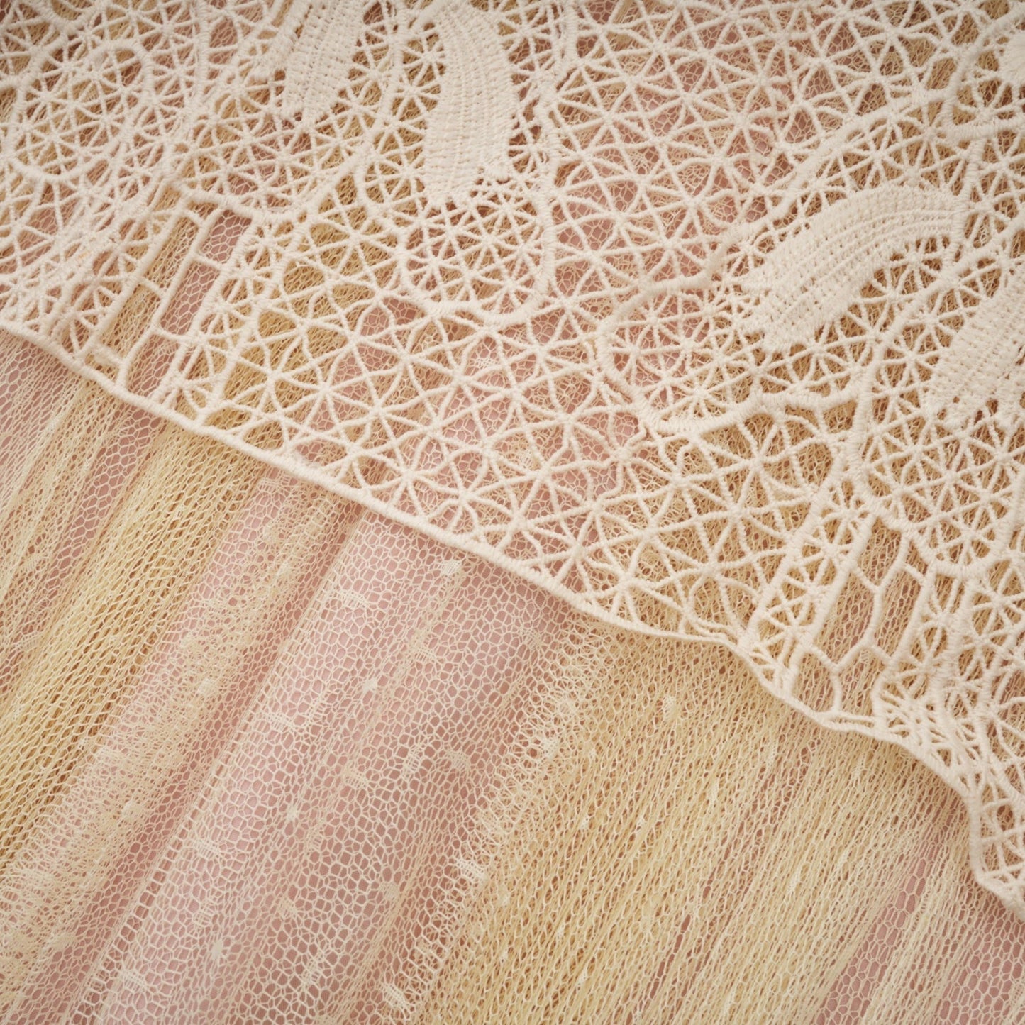 Woman wearing neutral colored midi dress with floral lace panels and tulle skirt