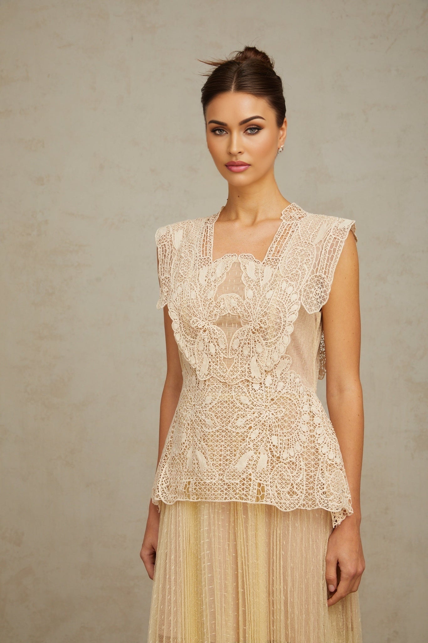 Woman wearing neutral colored tulle midi dress with floral lace panels and fitted bodice