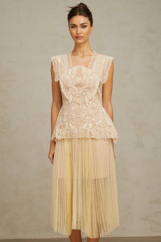 Woman wearing neutral colored tulle midi dress with floral lace panels delicate straps and flowing skirt