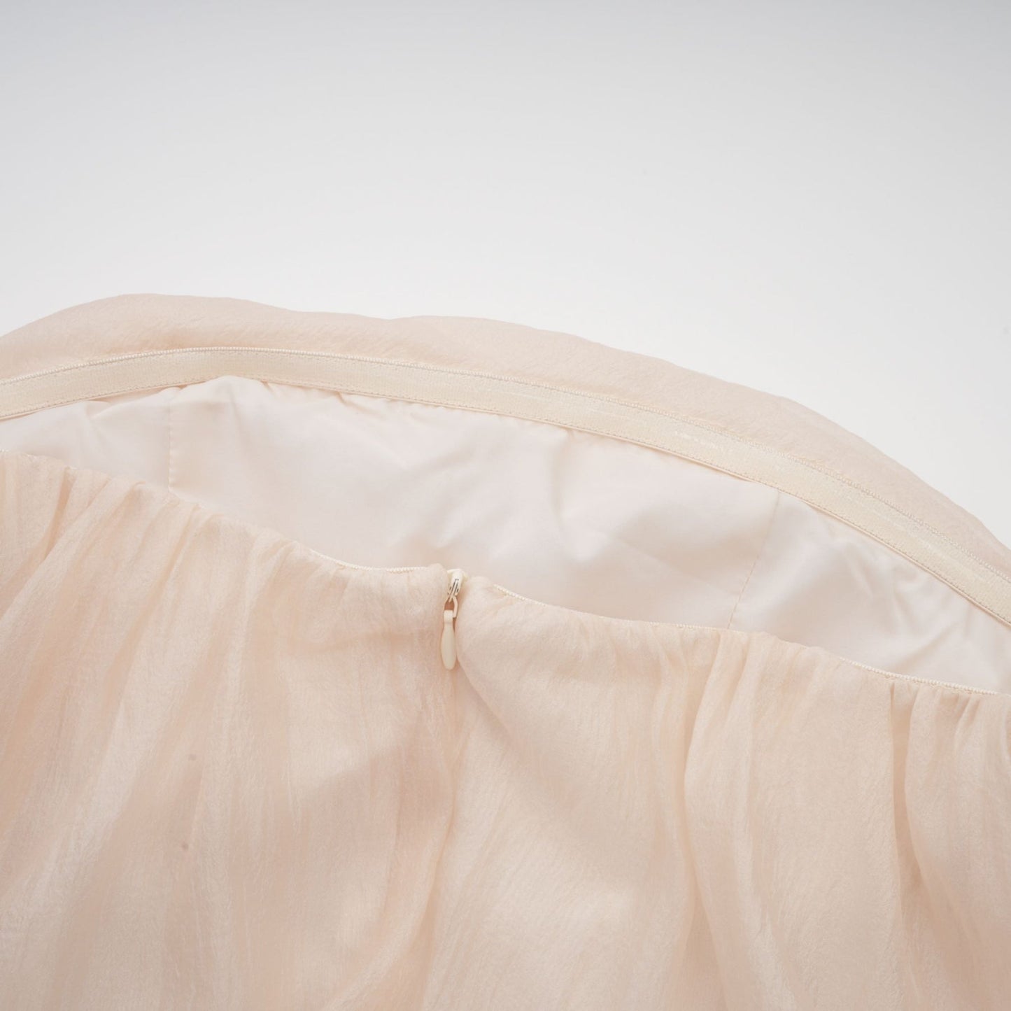 Woman wearing off shoulder mini dress with ruched layering and self tie detail