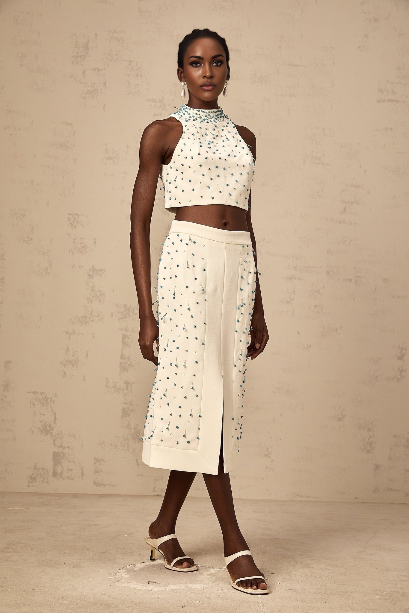 Woman wearing offwhite matching set consisting of embellished top and skirt named Clothilde