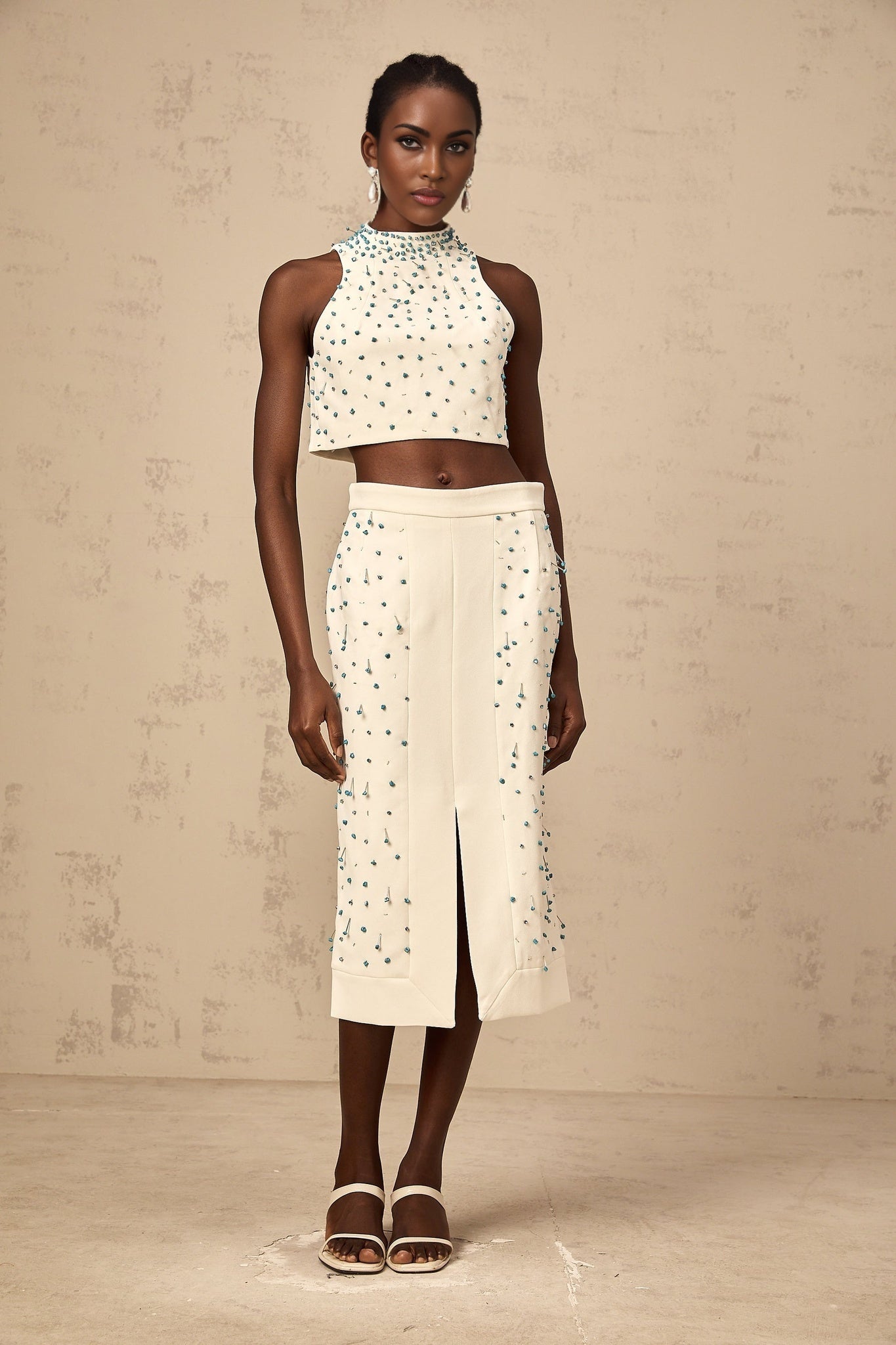 Woman wearing offwhite matching set with embellished top and skirt called Clothilde
