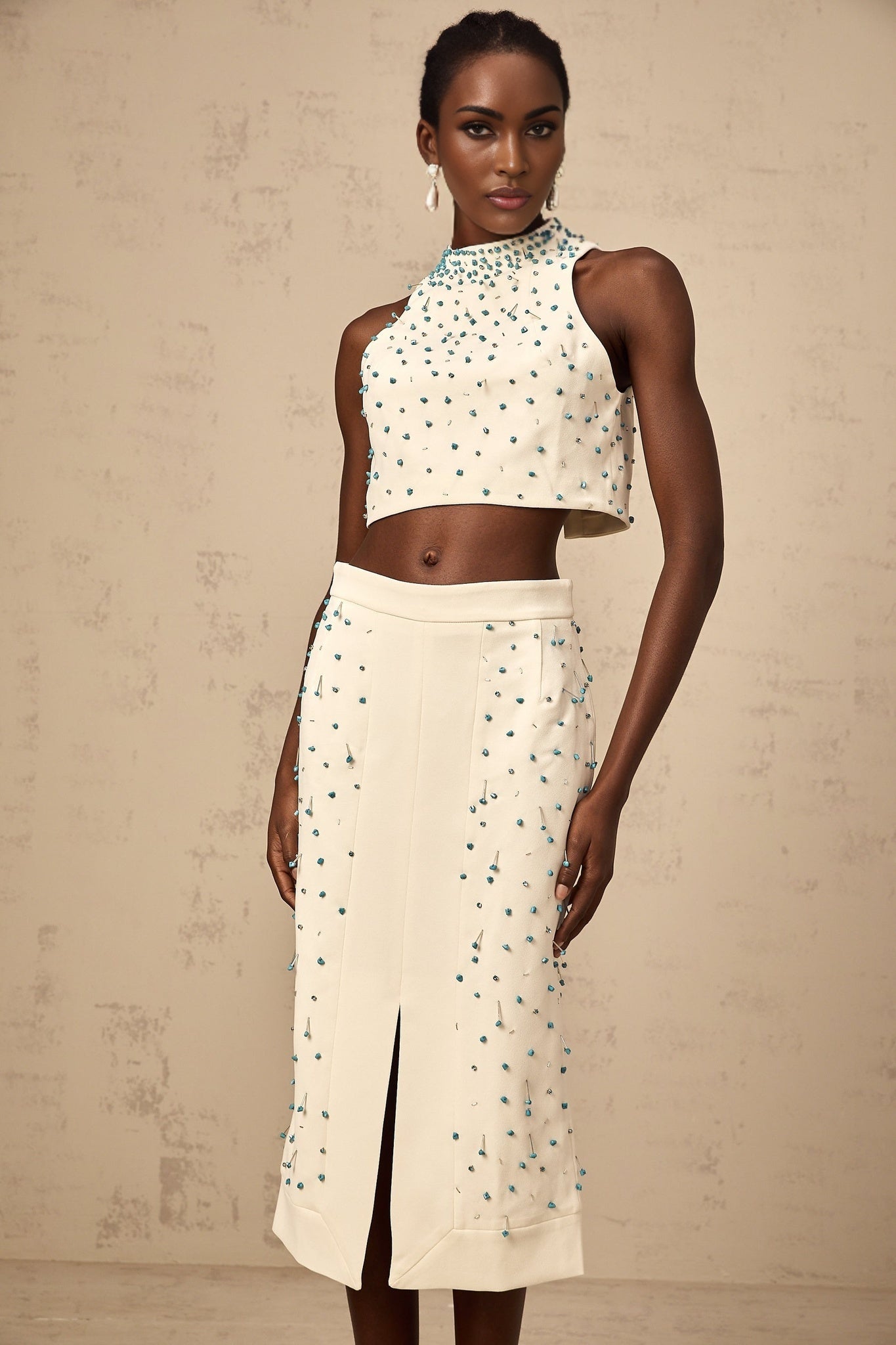 Woman wearing offwhite matching set with embellished top and skirt named Clothilde