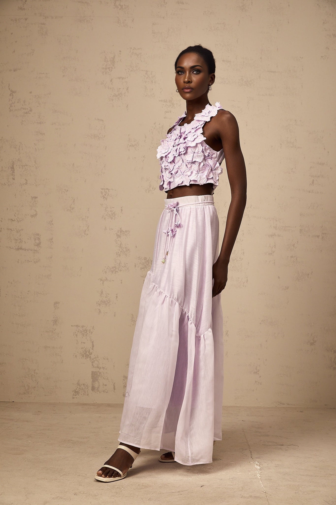 Woman wearing purple floral top and matching skirt set with faux flower pattern