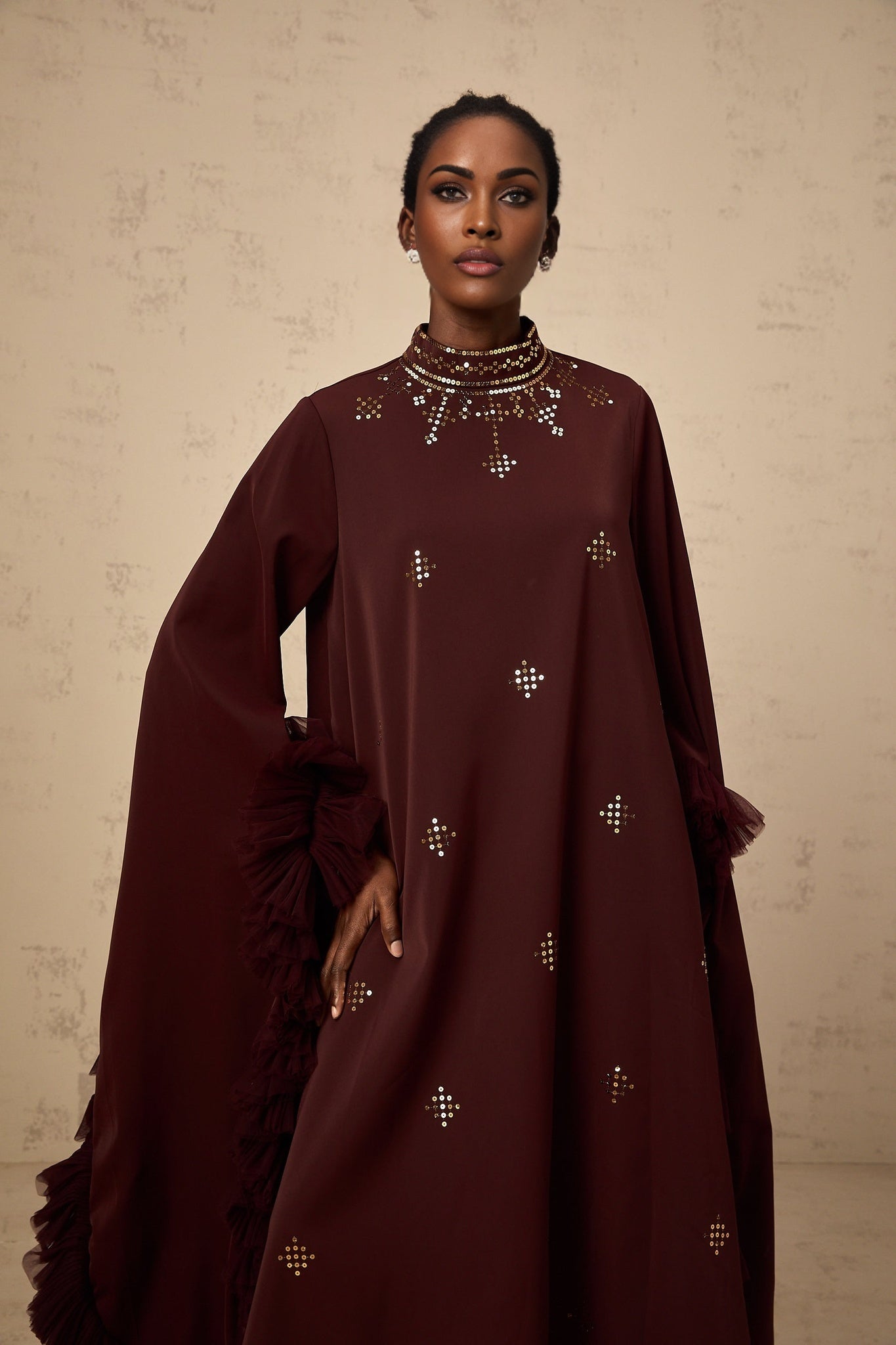 Woman wearing purple sequined midi dress with flared sleeves