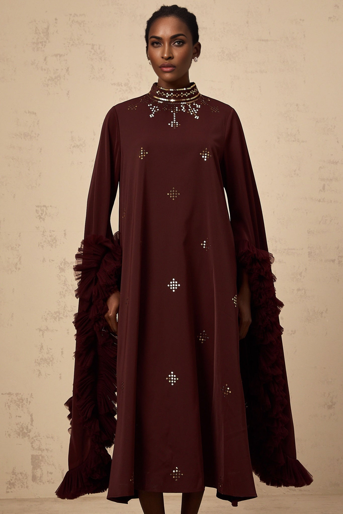 Woman wearing purple sequined midi dress with flared sleeves