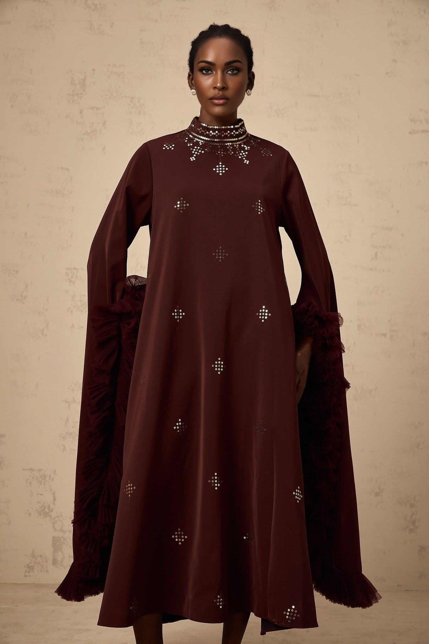 Woman wearing purple sequined midi dress with flared sleeves