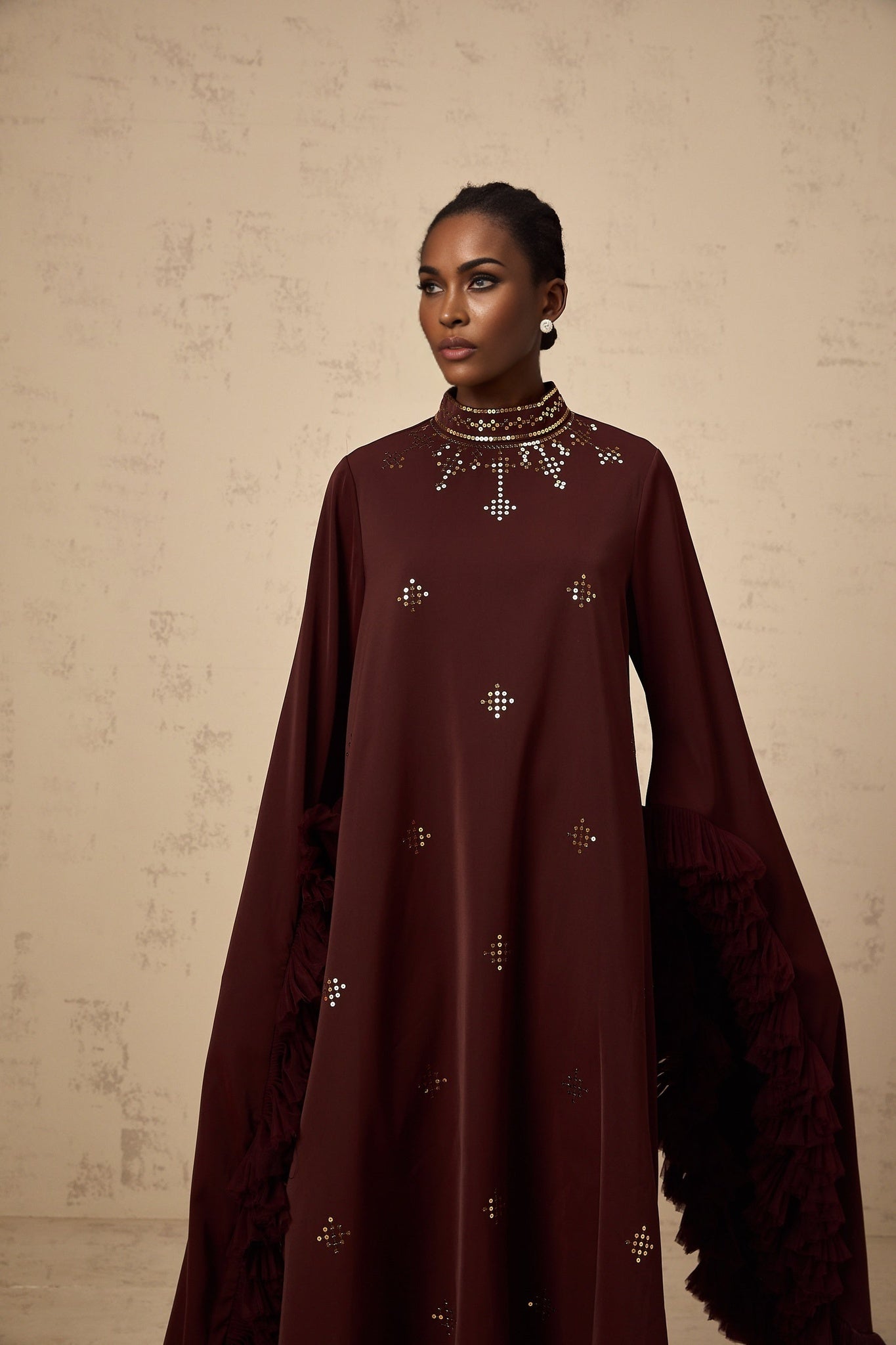 Woman wearing purple sequined midi dress with flared sleeves