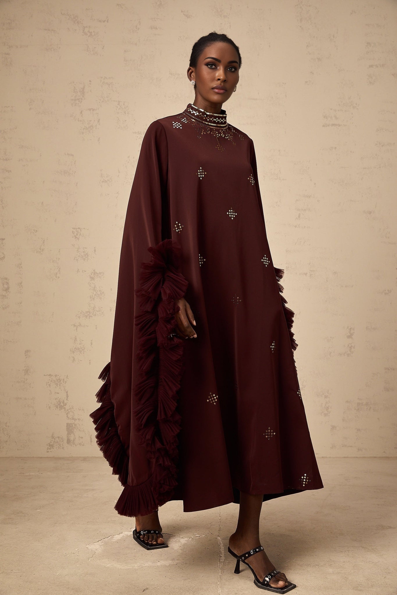 Woman wearing purple sequined midi dress with flared sleeves
