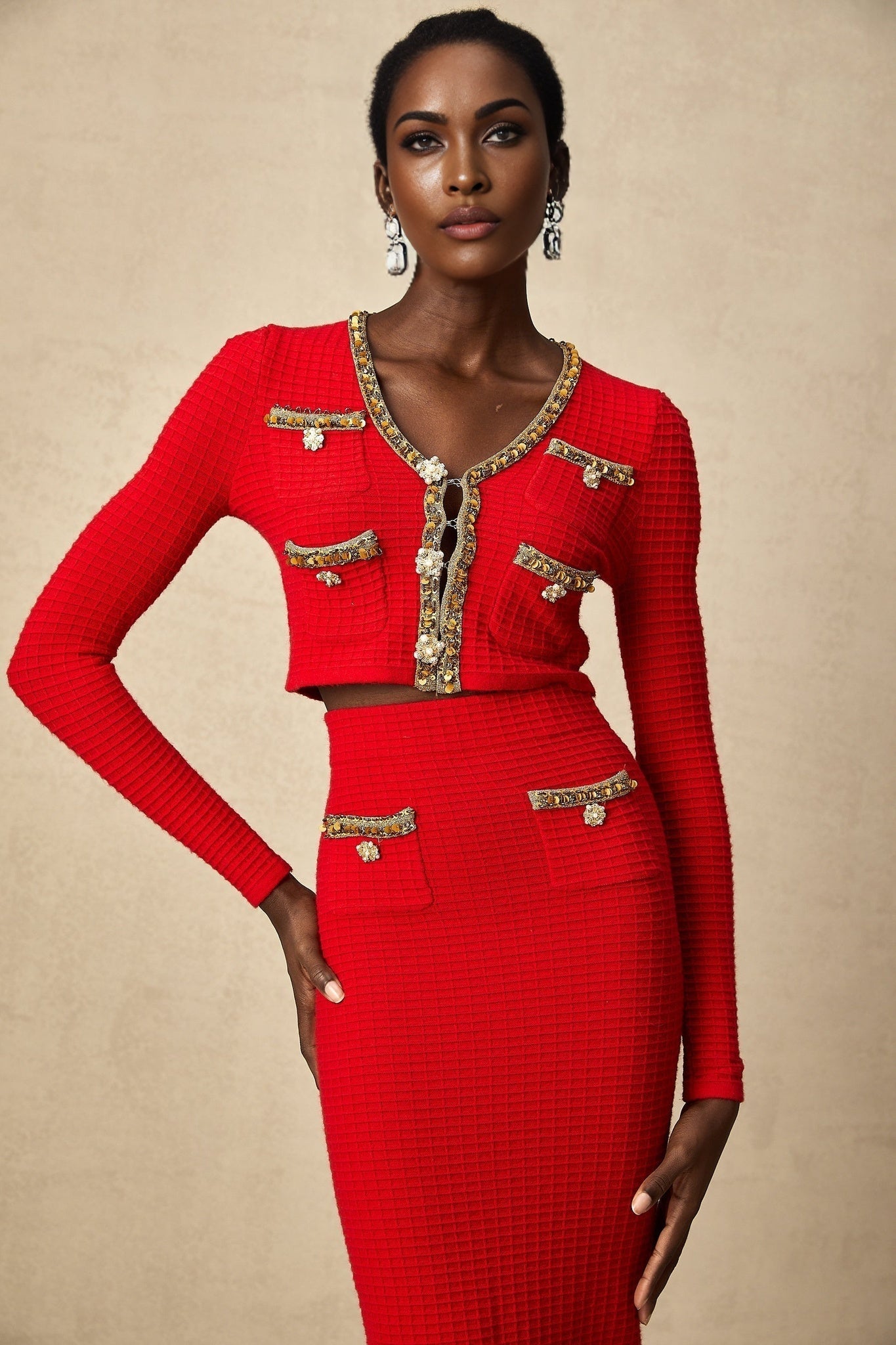 Woman wearing red knitted cardigan and matching skirt with embellished details Axelle set