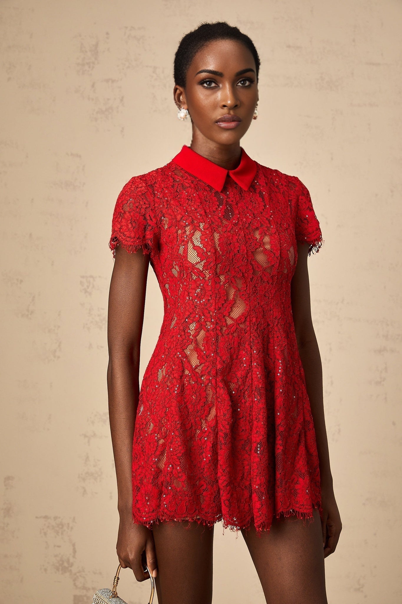 Woman wearing red mini dress with sequined lace detail