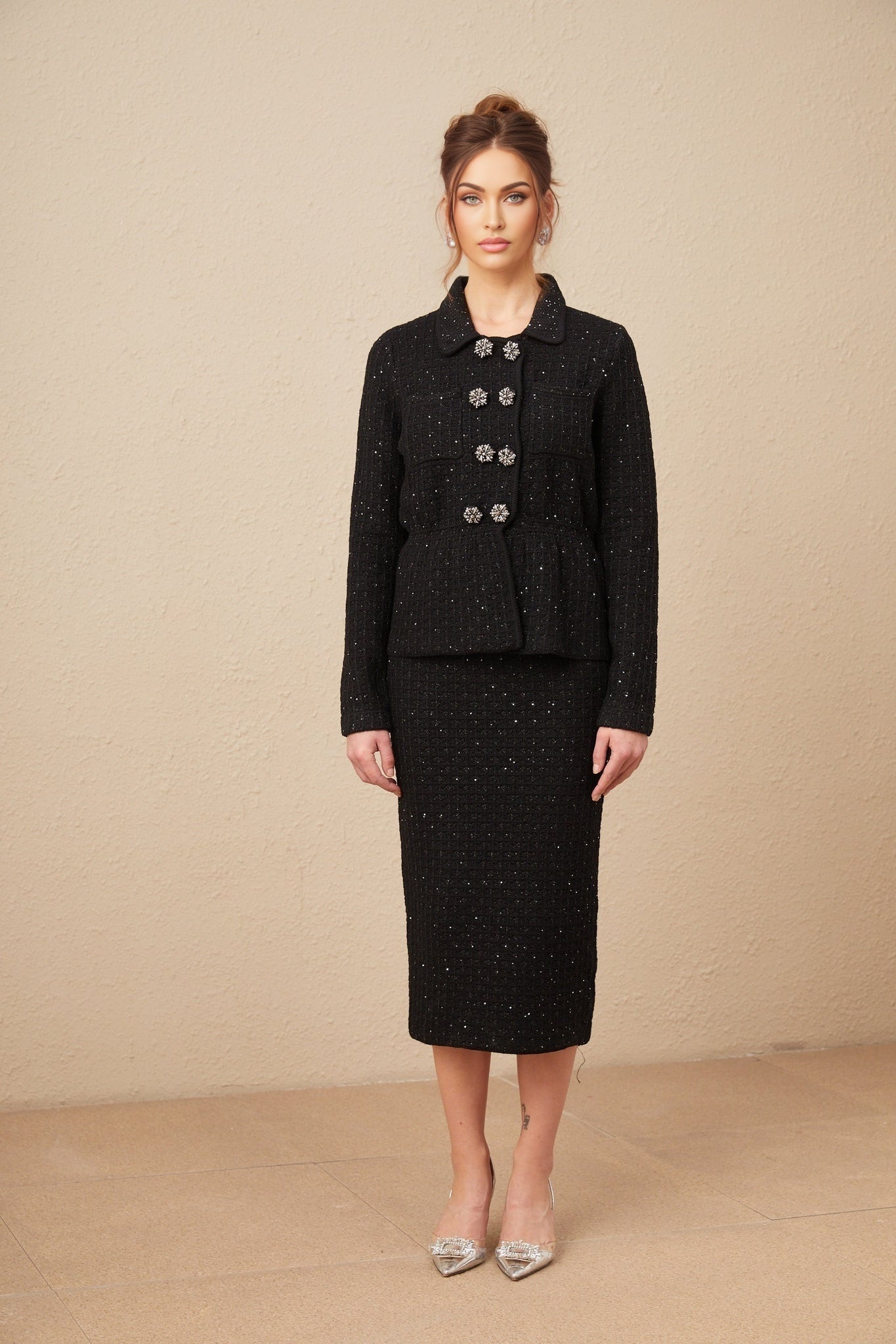 Woman wearing sequined waffle knit jacket and matching skirt set in shimmering Amina design