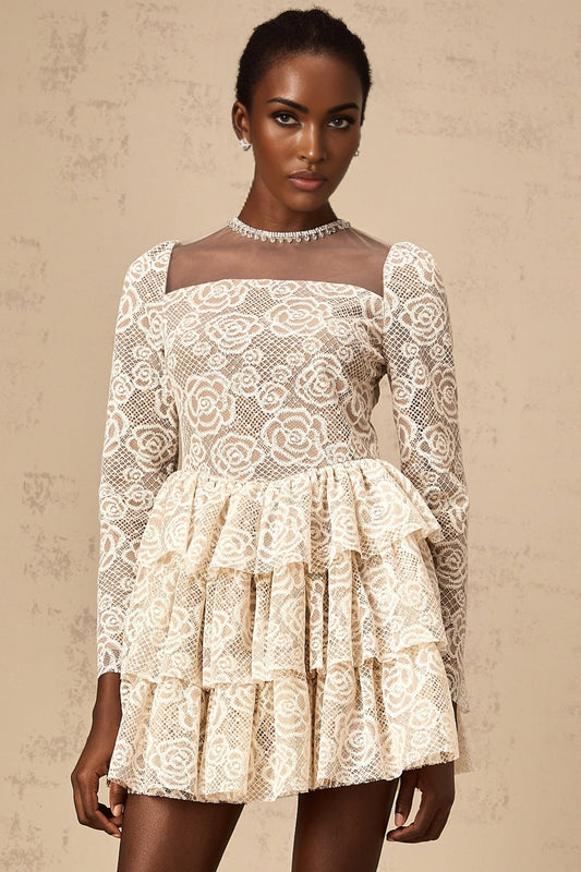 Woman wearing short beige dress with delicate floral embroidery detail and thin straps