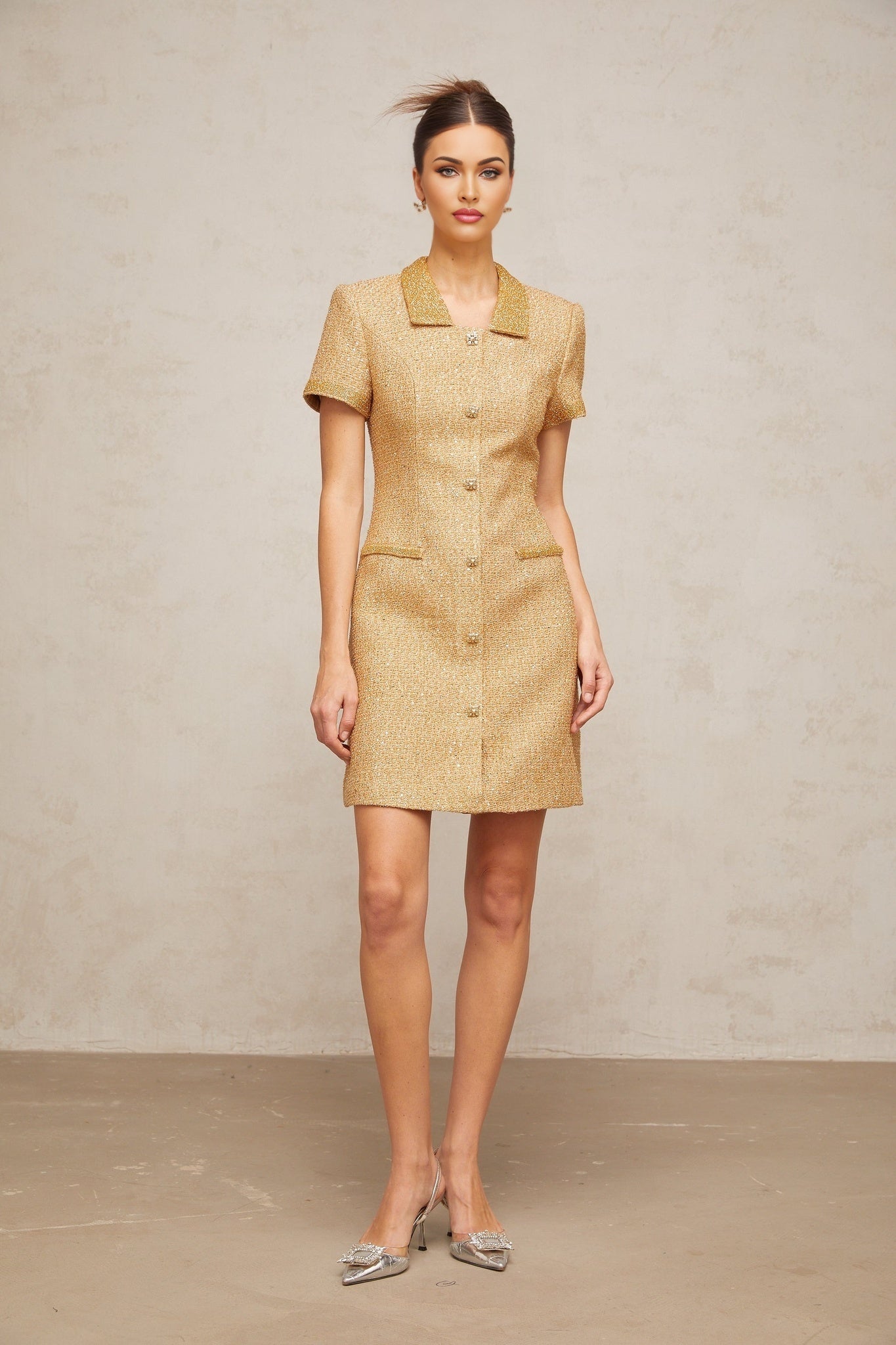 Woman wearing short gold dress with sequins and tweed texture