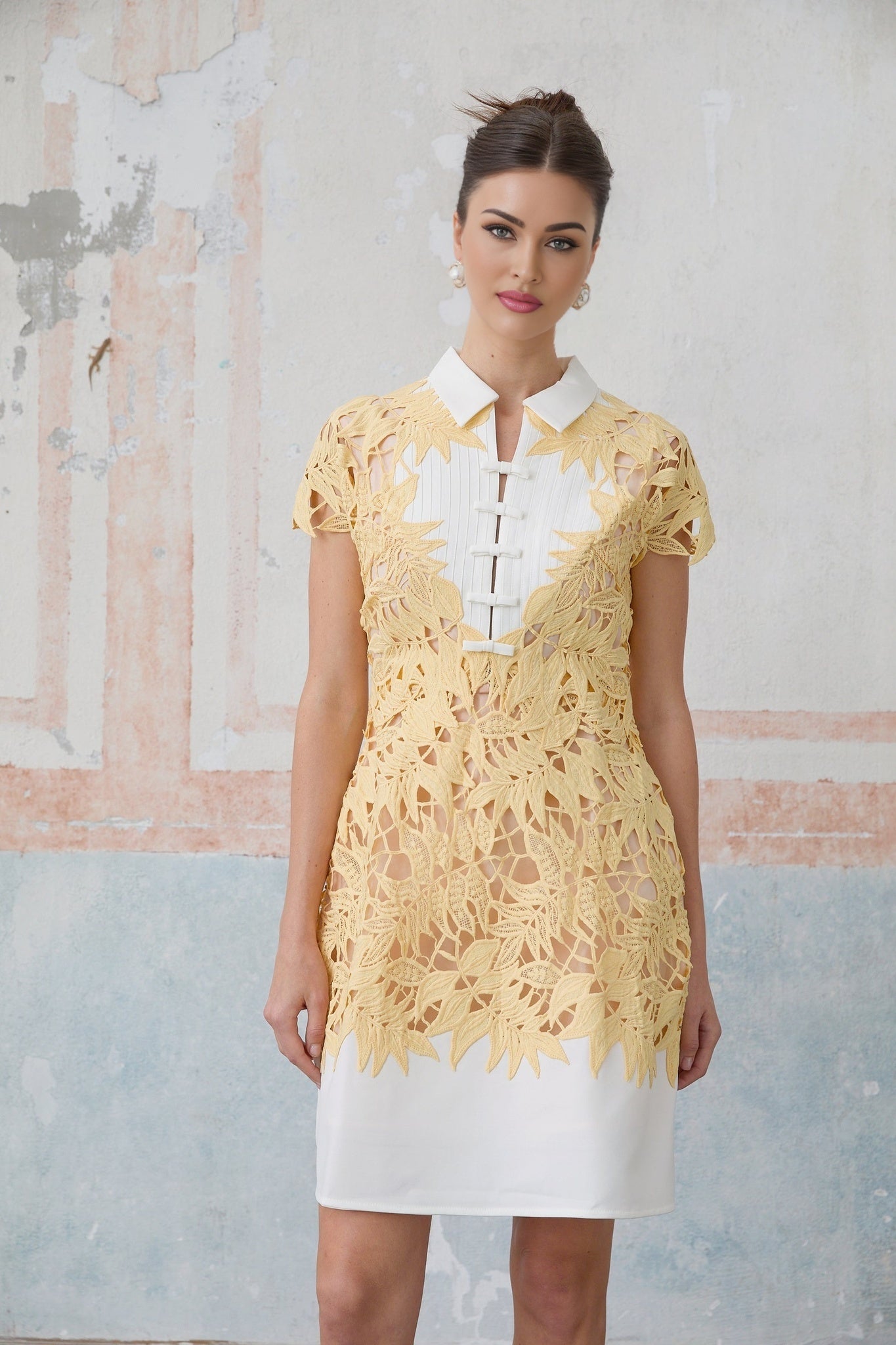 Woman wearing short yellow dress with leaf applique design