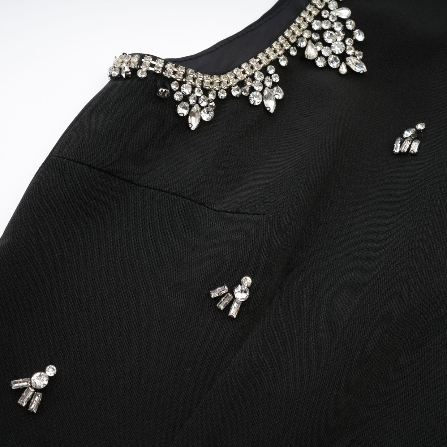 Black dress with accentuating contrast colors sleeveless design classy round neck unique cutout design sparkling crystal embellishments rear zip fastening stylish thigh length composed of 100% Polyester