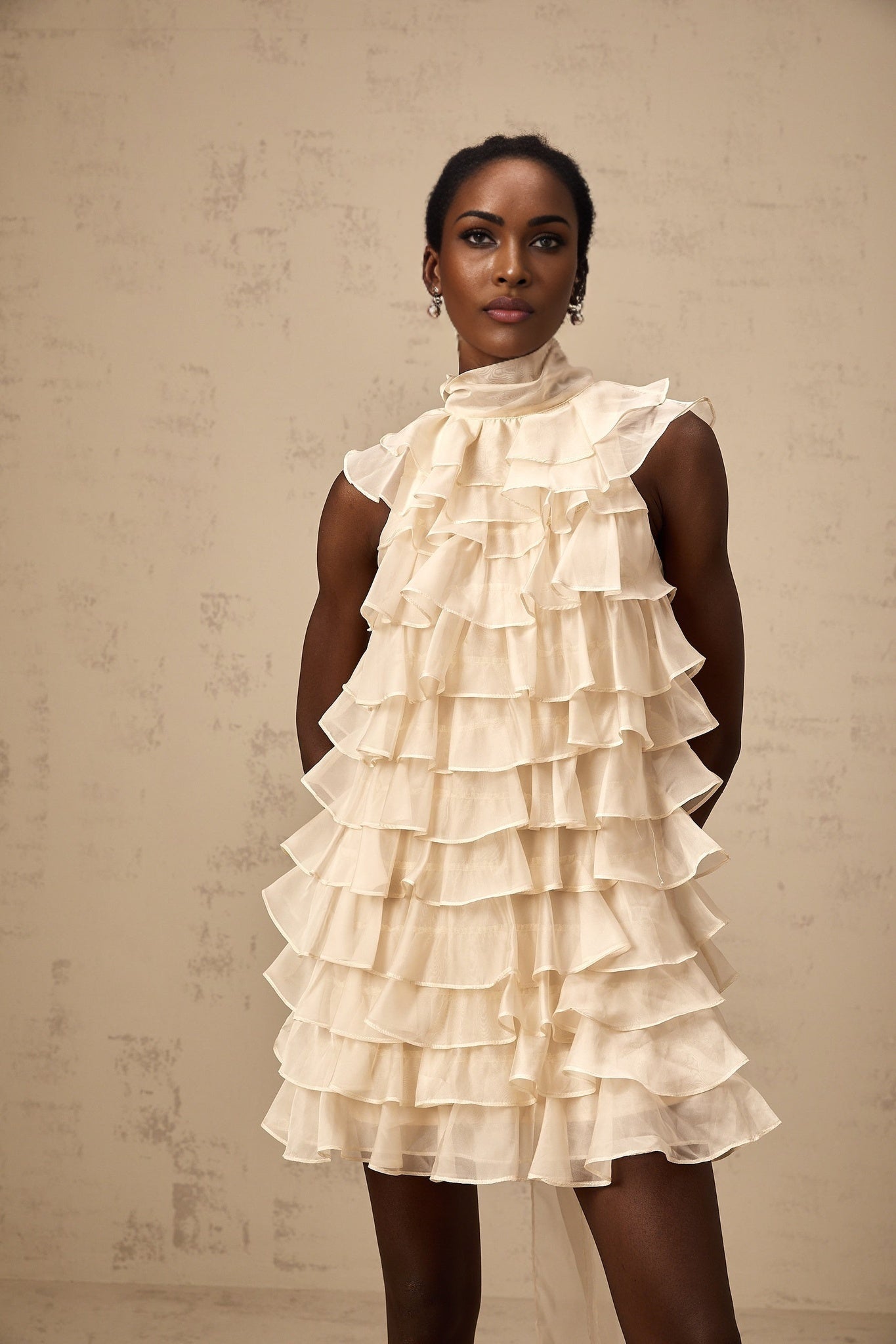 Woman wearing sleeveless mini dress with tiered flounce design