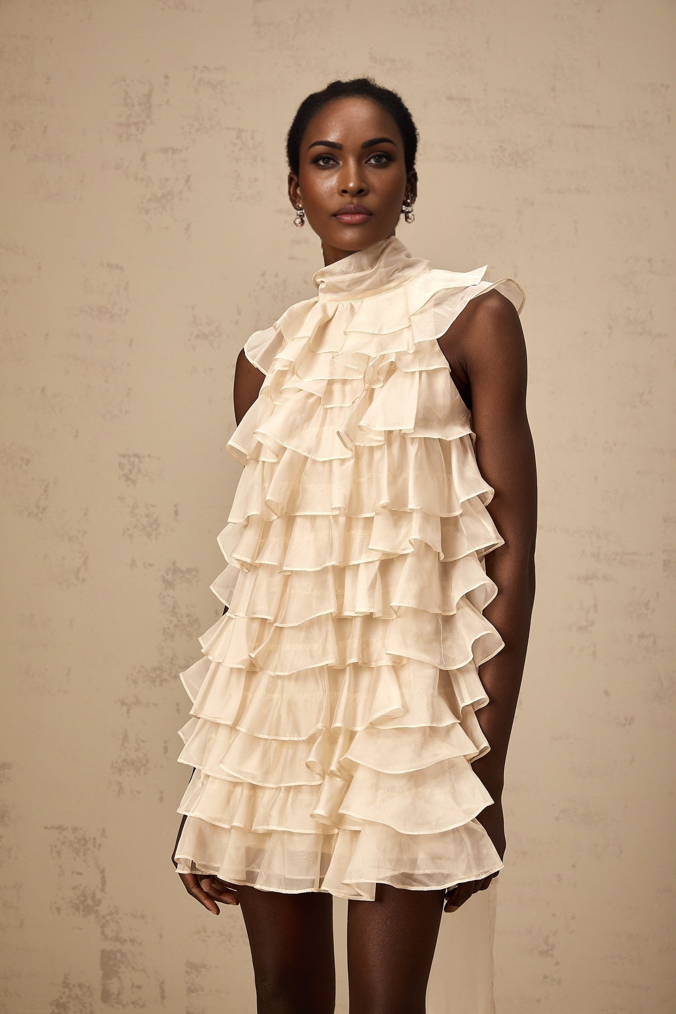 Woman wearing sleeveless mini dress with tiered flounce detail