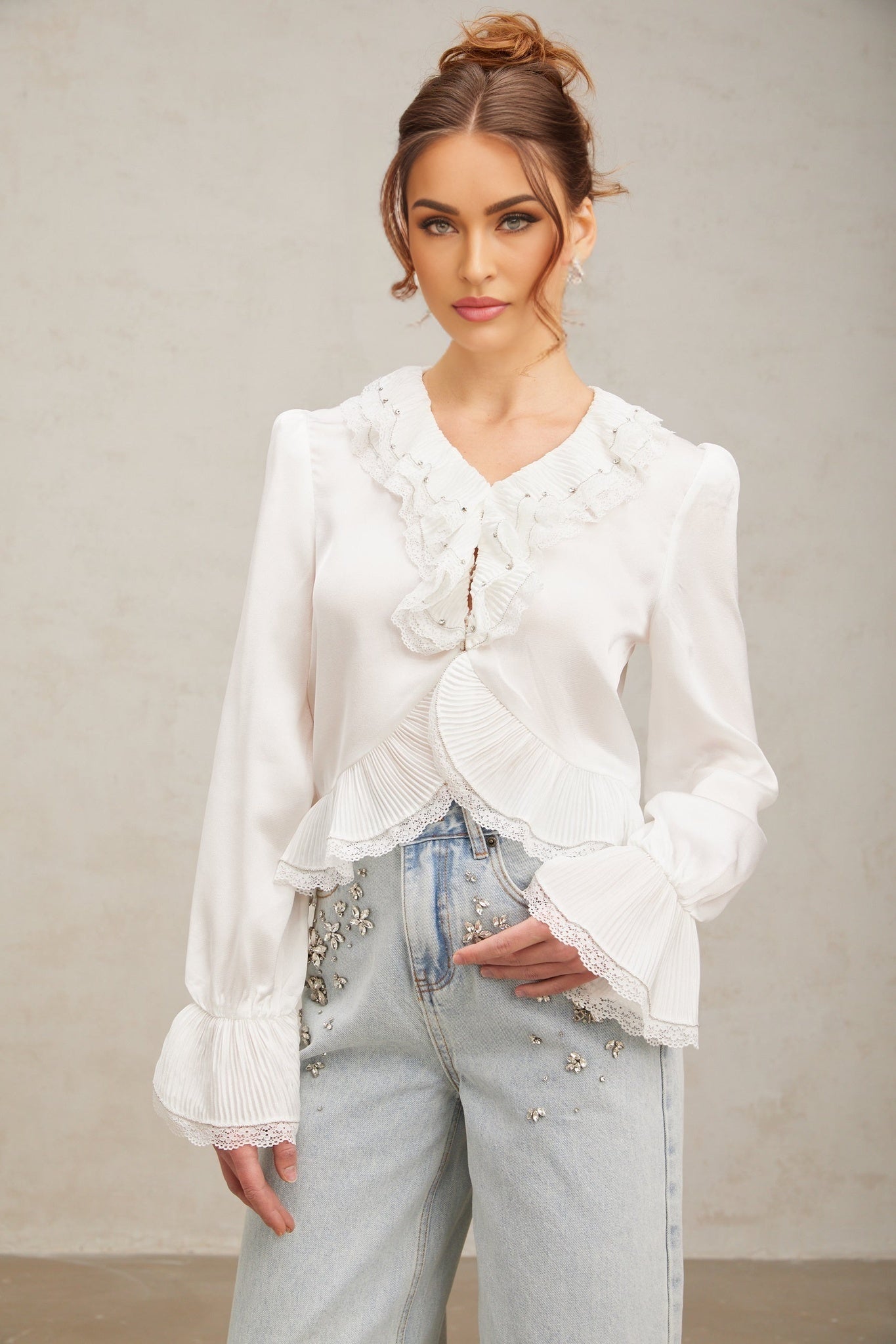 Woman wearing white blouse with lace trim and ruffled details