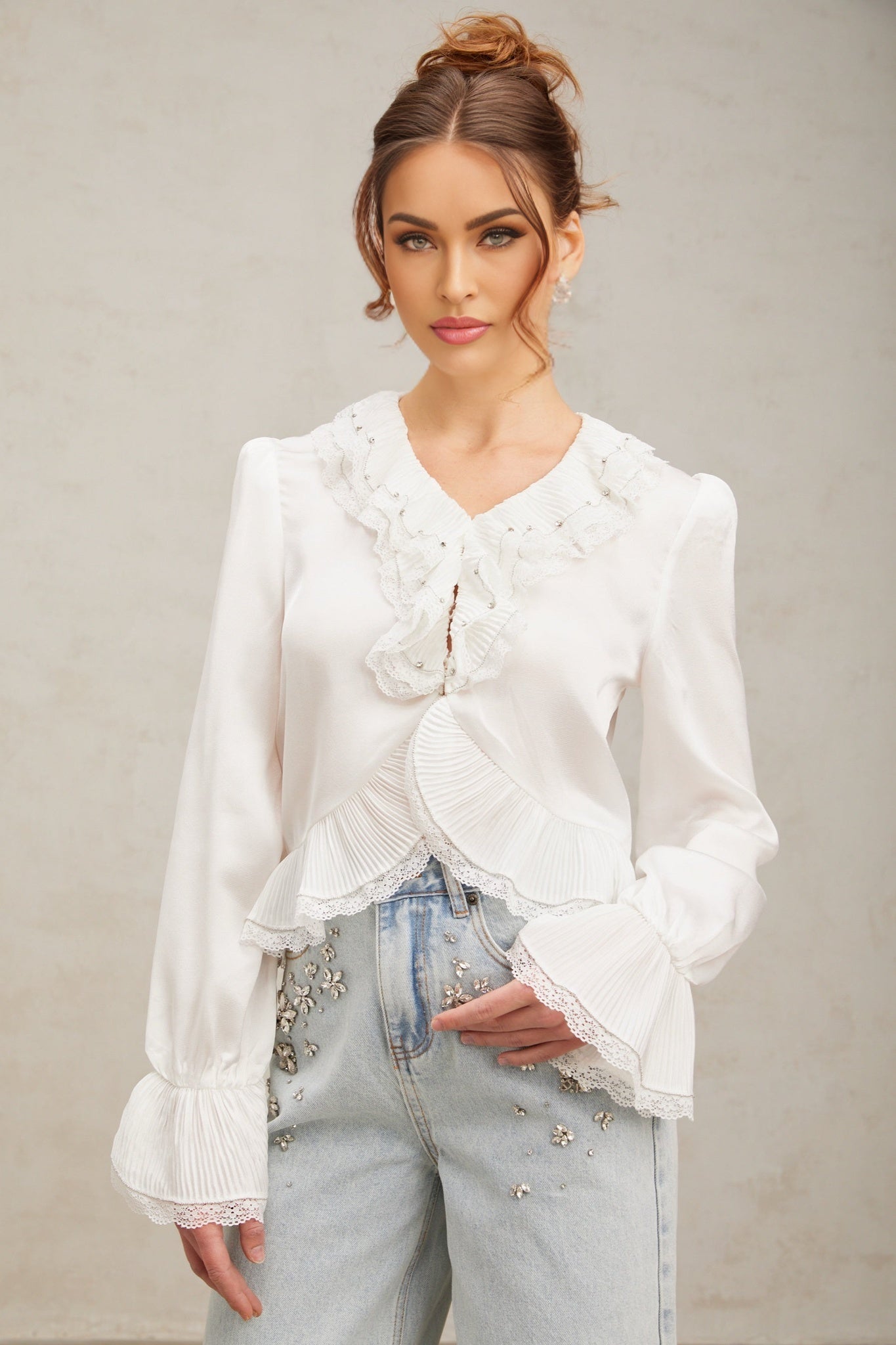 Woman wearing white buttonup shirt with lace trim and ruffled details