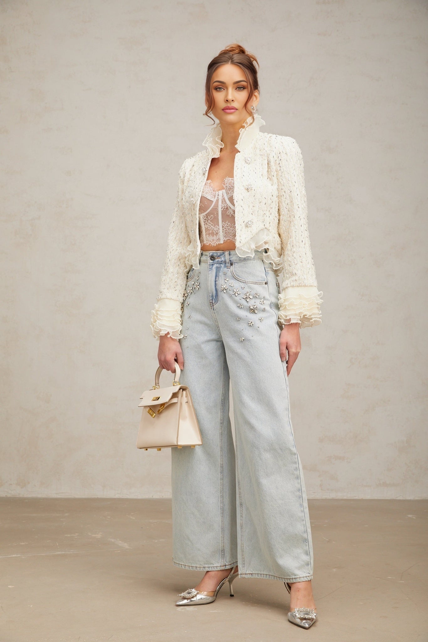 Woman wearing white cropped jacket with beaded details and ruffle trim