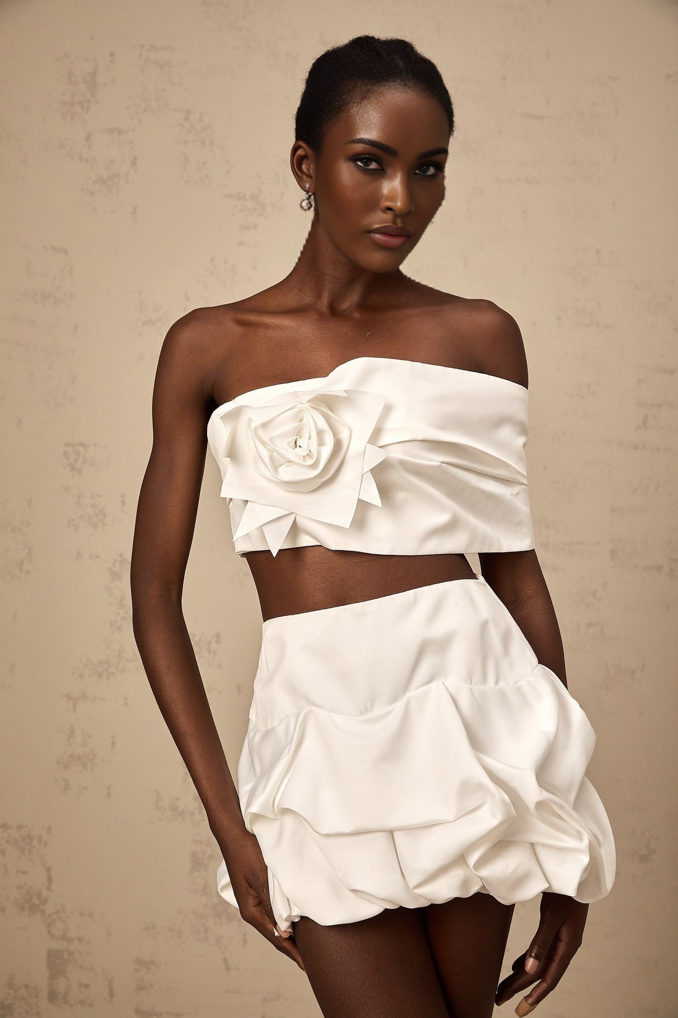 Woman wearing white floral printed matching set with pleated top and skirt by Honorine