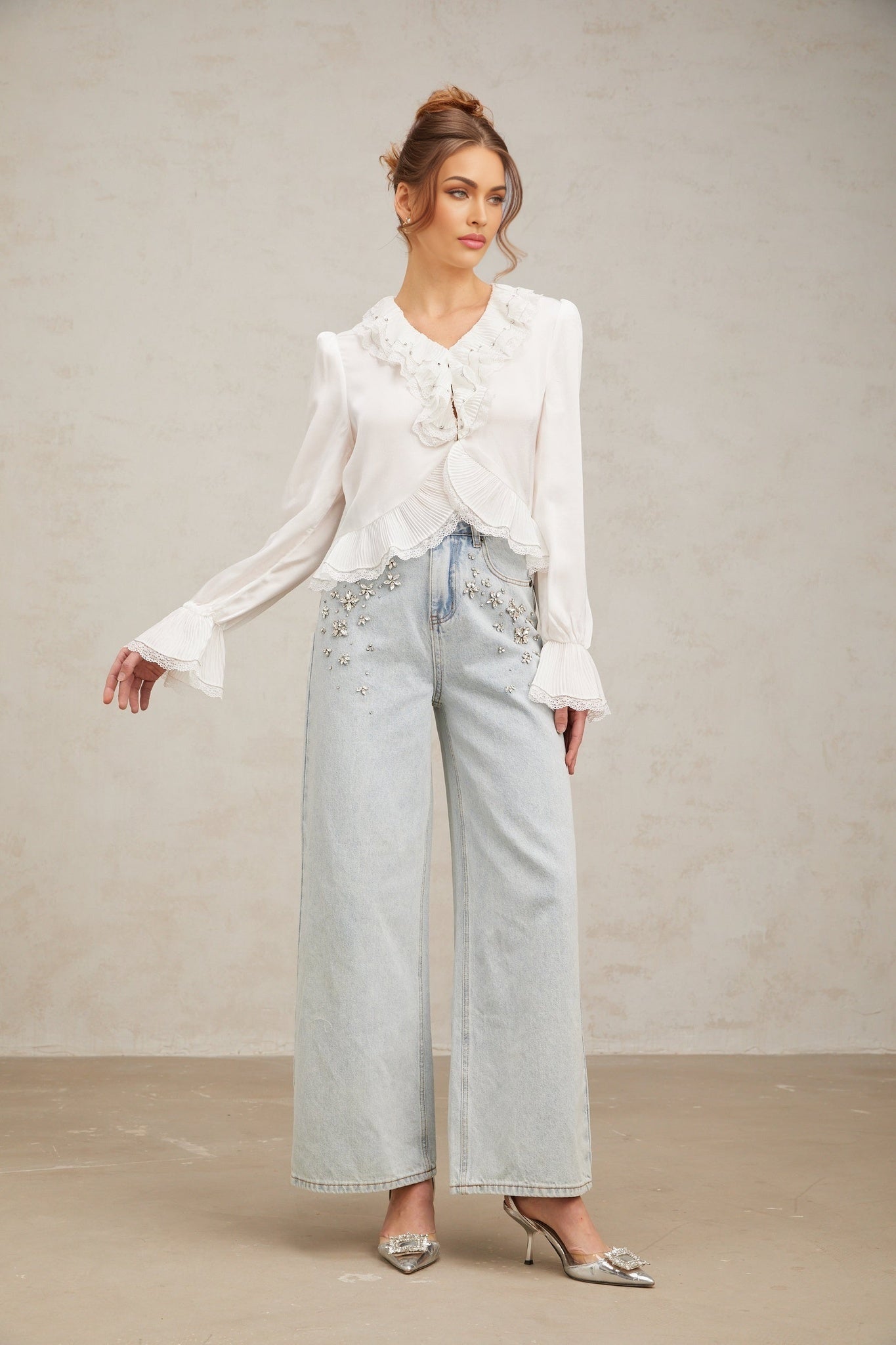Woman wearing white long sleeve shirt with lace trim and ruffled details