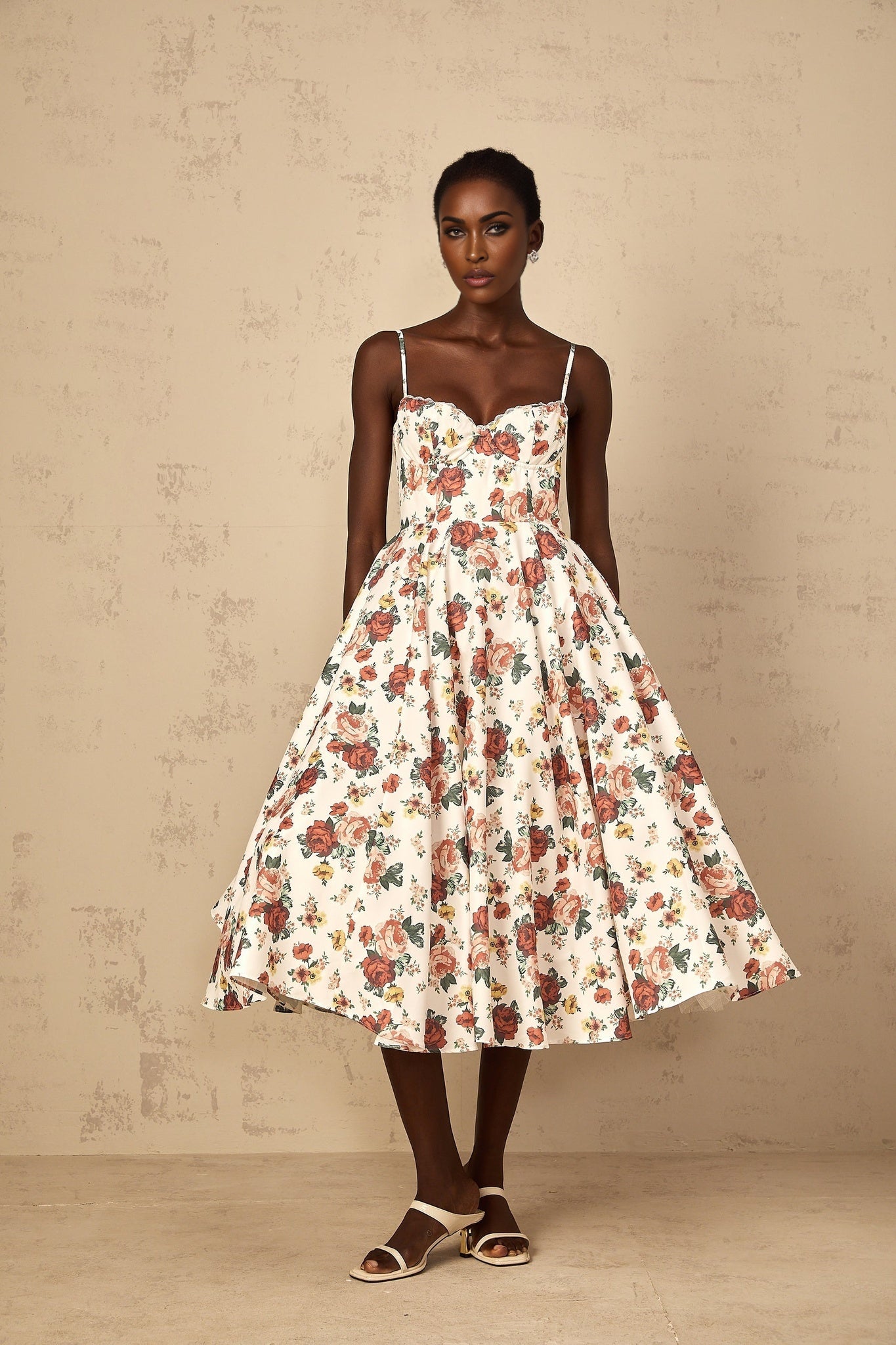 Woman wearing white midi dress with rose print pattern and flounced details