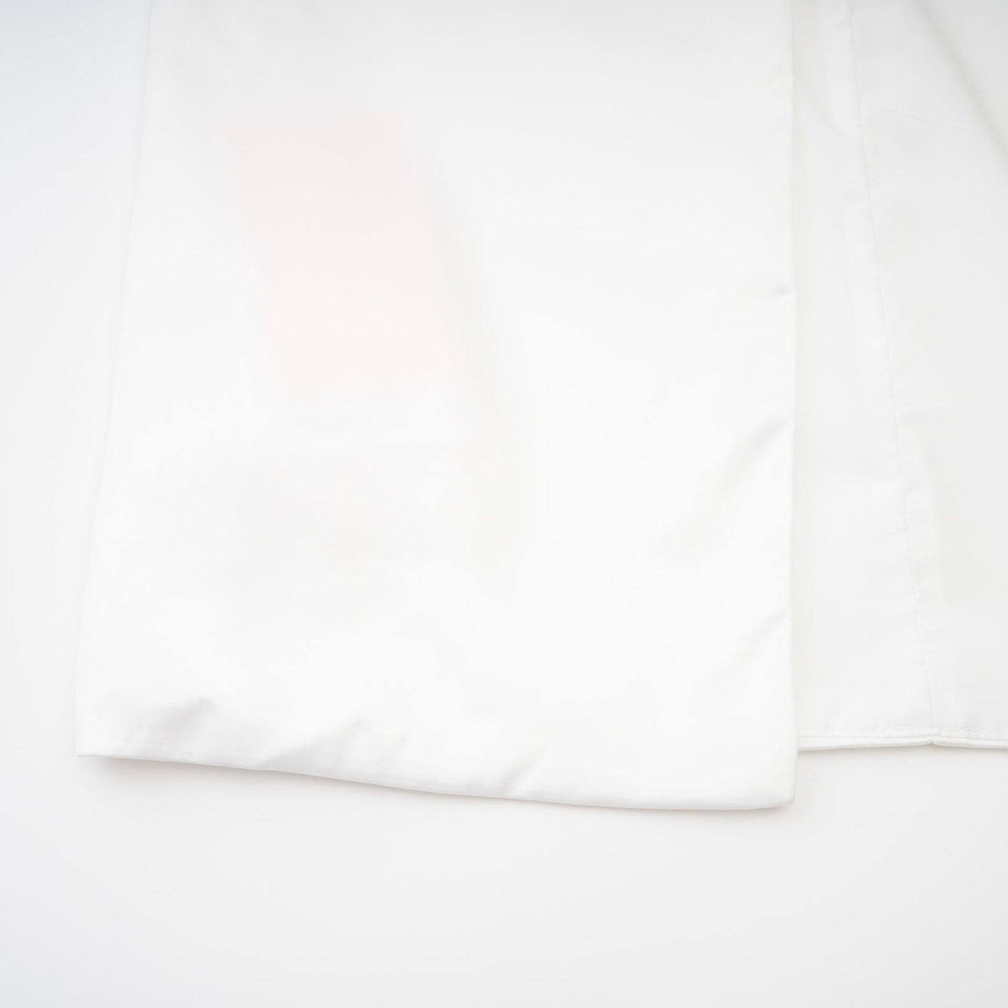 Woman wearing white off the shoulder dress with flowing fabric and delicate design