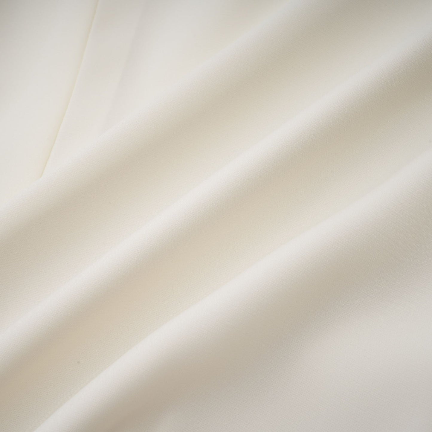 Woman wearing white pleated jacket and dress set with embellishments Blanche design