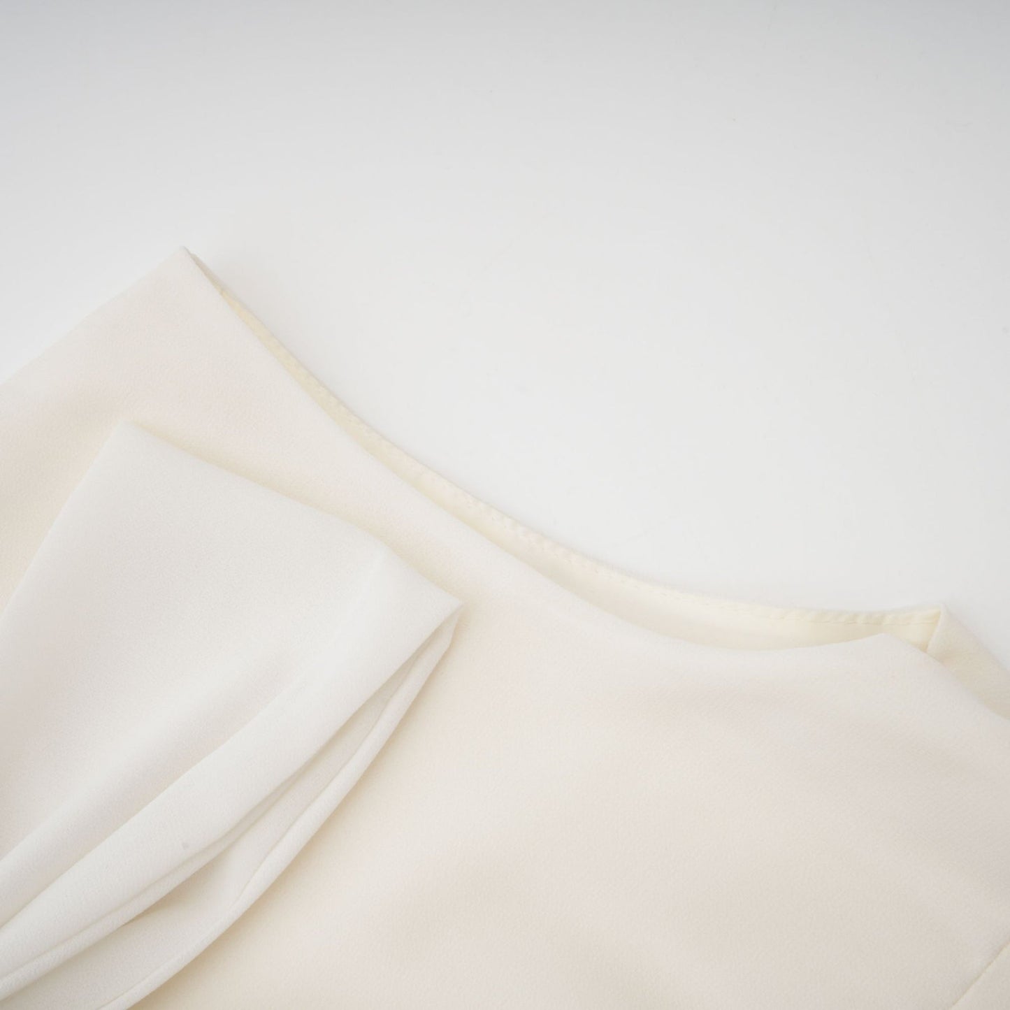 Woman wearing white pleated jacket and dress set with embellishments Blanche matching outfit elegant formal wear