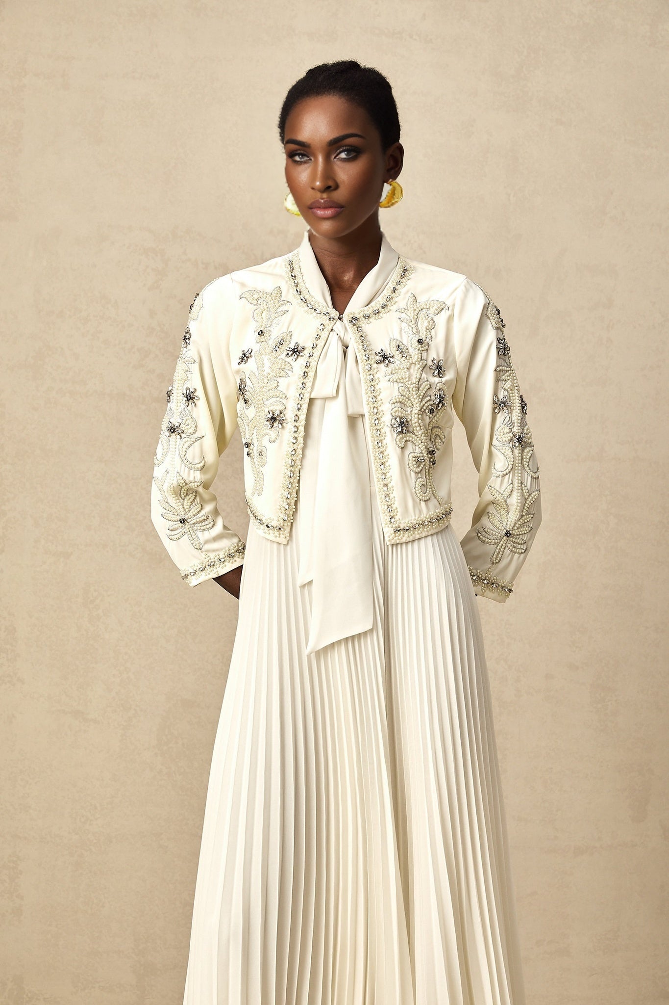 Woman wearing white pleated jacket and dress set with embellishments Blanche matching outfit formal wear