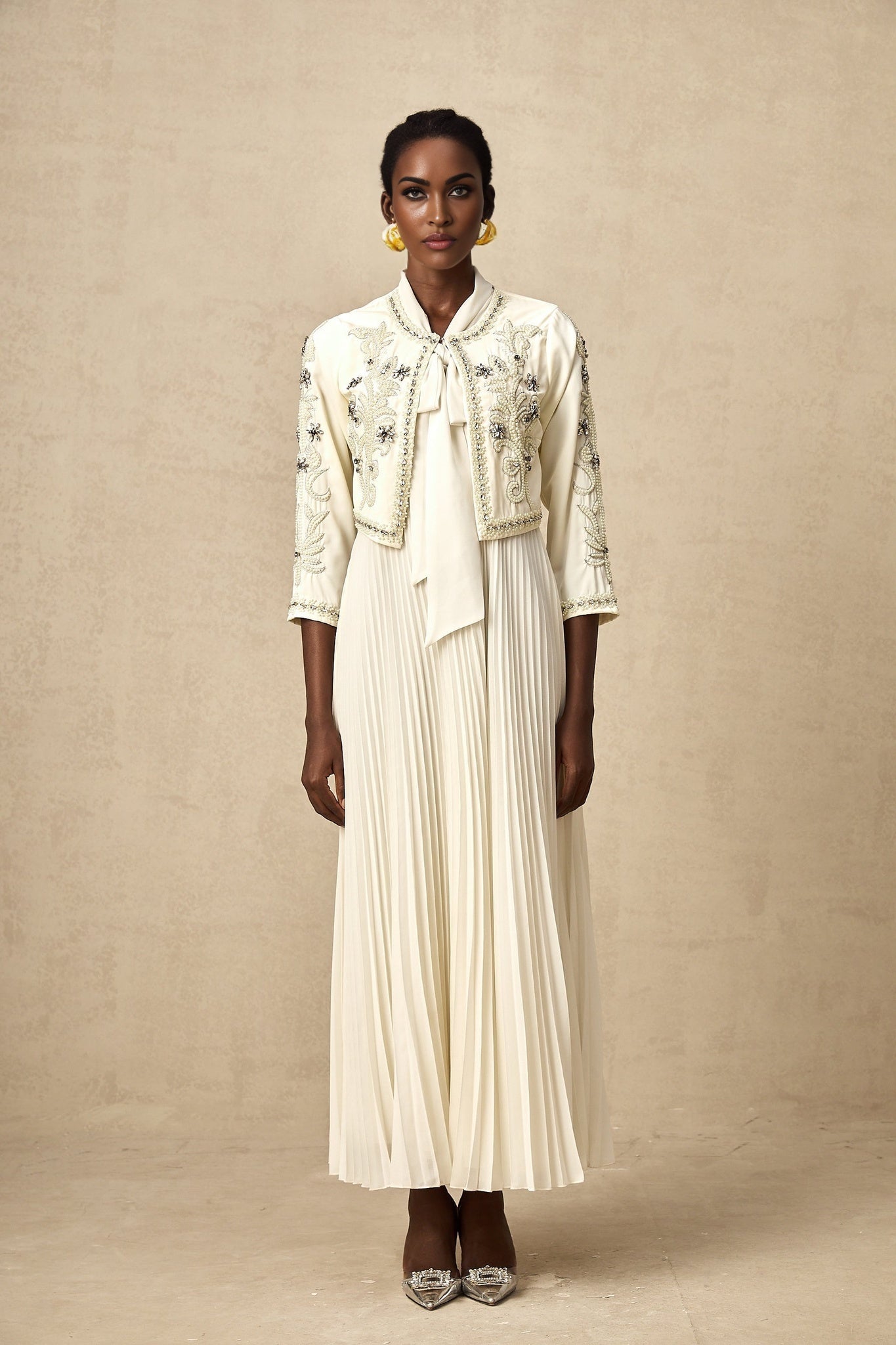 Woman wearing white pleated jacket and dress set with embellishments Blanche style matching outfit