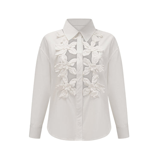 Woman wearing white shirt with floral pattern and cut out details