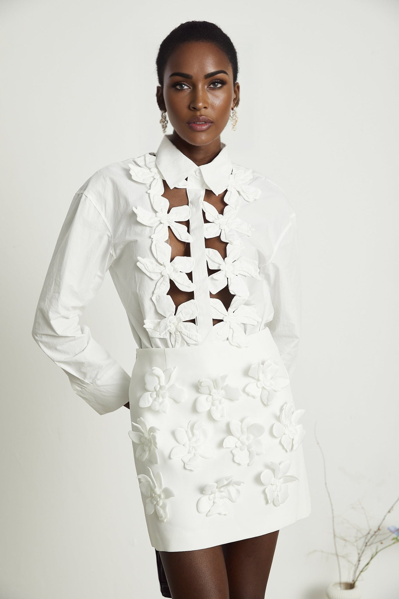 Woman wearing white shirt with floral pattern and cutout details