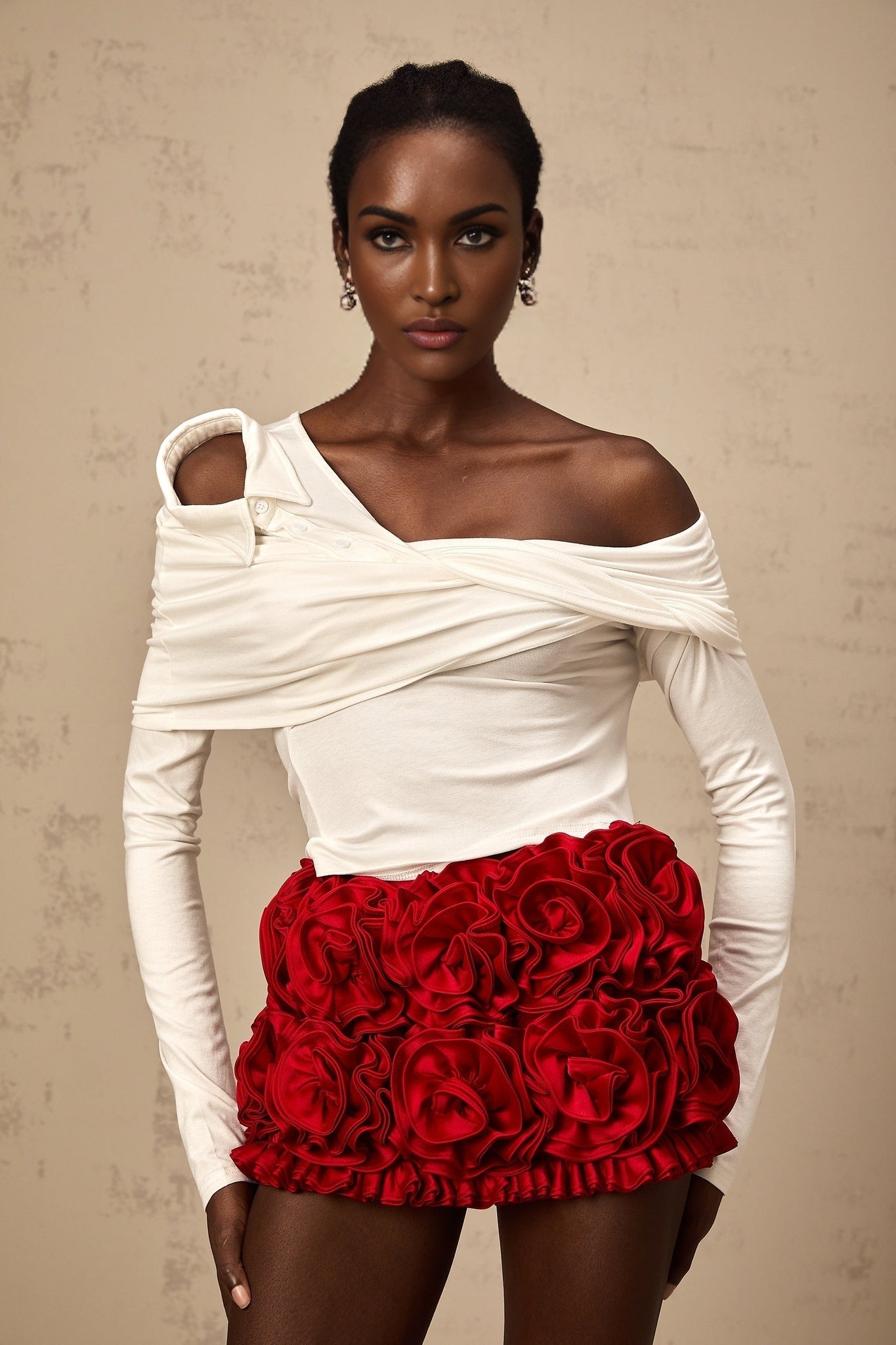 Woman wearing white sleeveless jersey top with asymmetric neckline and twisted fabric detail
