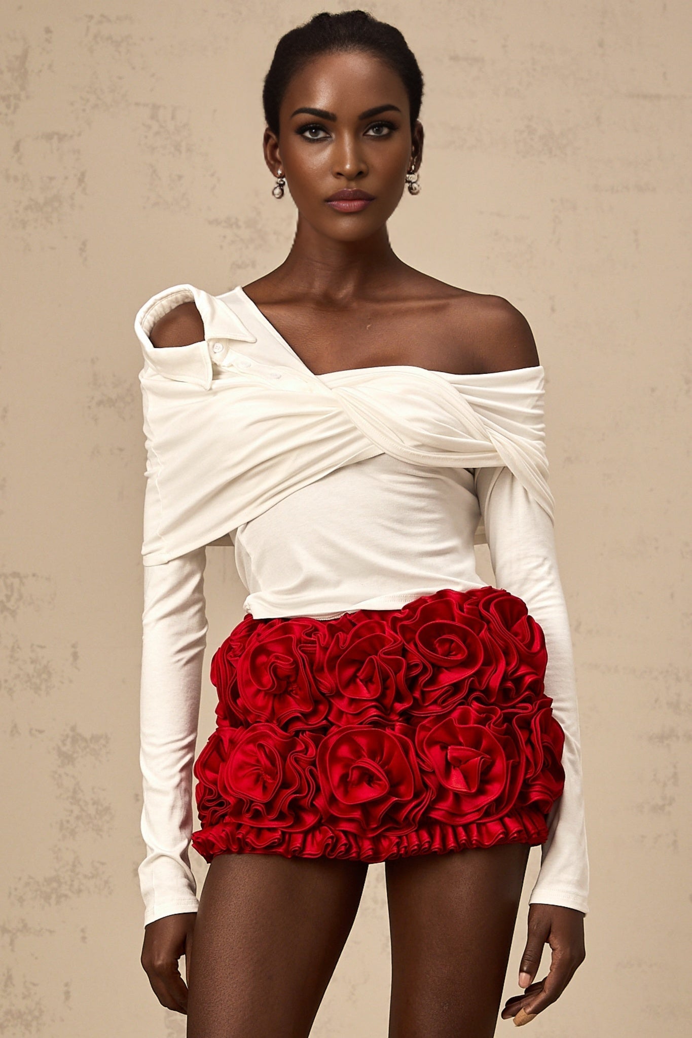 Woman wearing white sleeveless top with asymmetric neckline and twisted fabric detail
