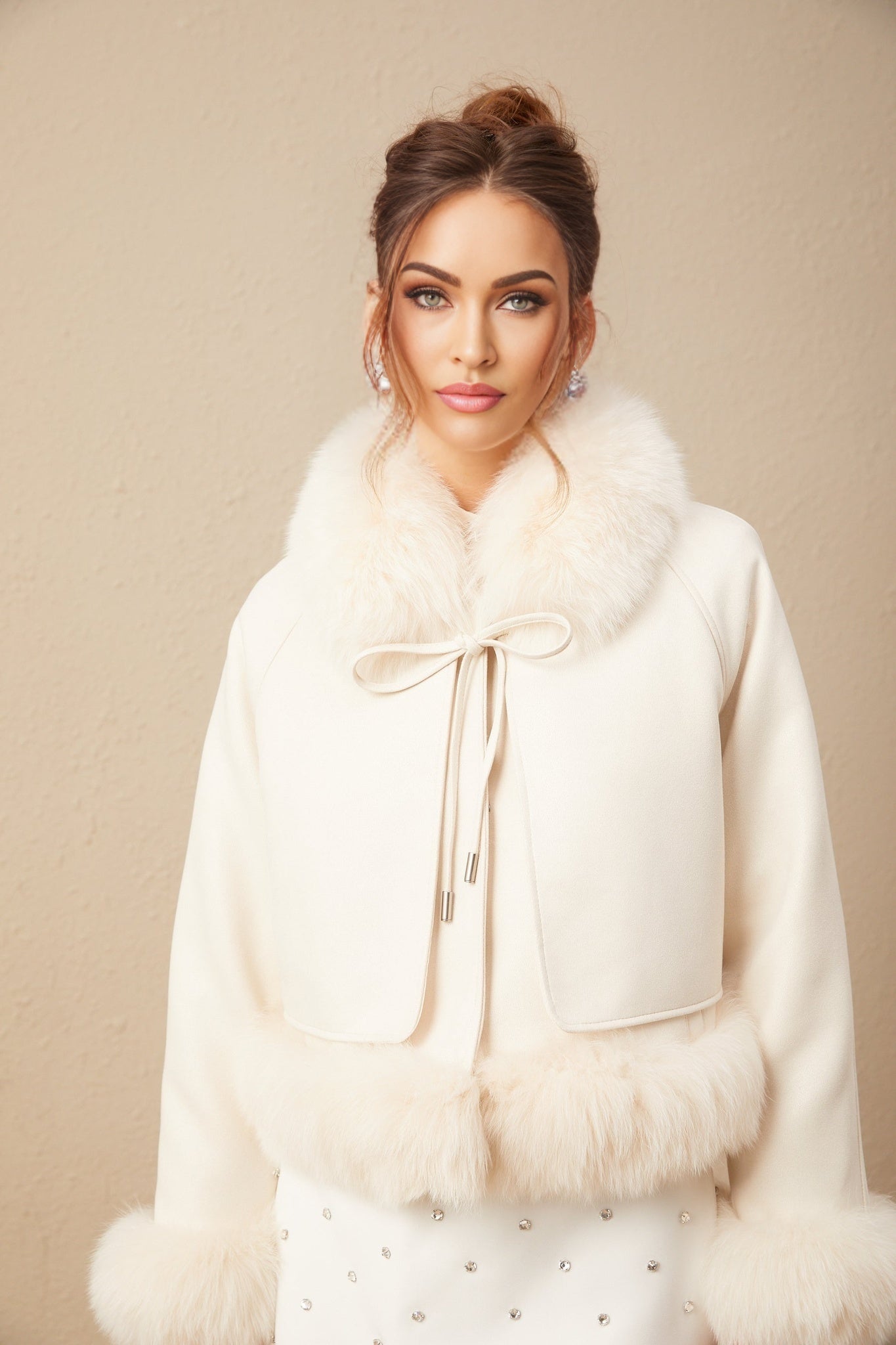 Woman wearing white suede short coat with fur trim and padded design