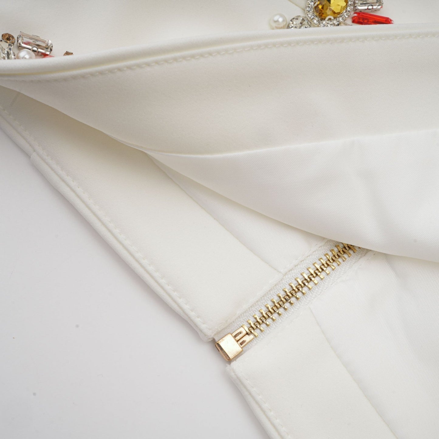 Woman wearing white twopiece outfit with crystal embellishments top and skirt set called Jeanne