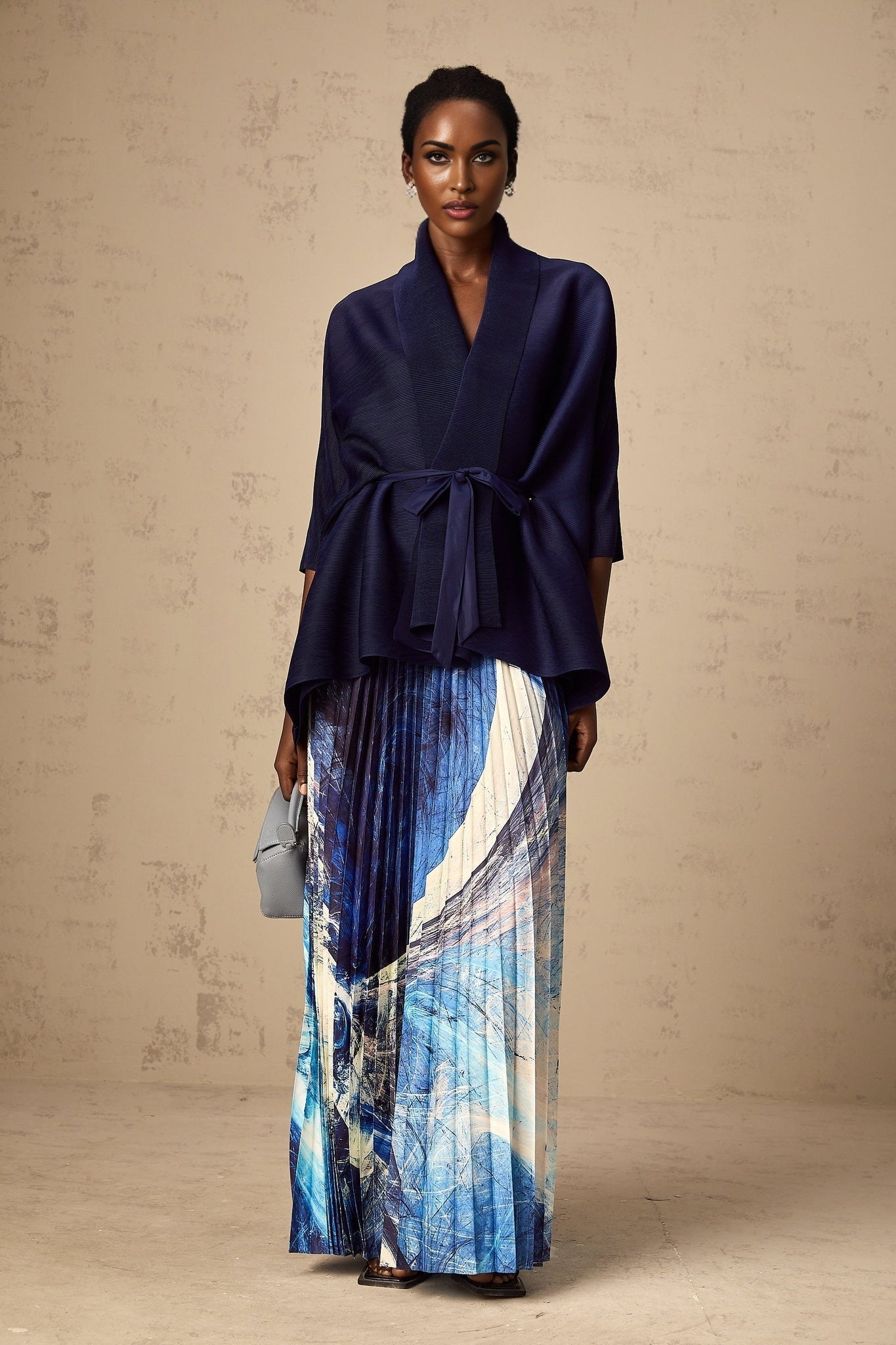 Womens blue patterned two piece outfit featuring a creased cape top and matching skirt