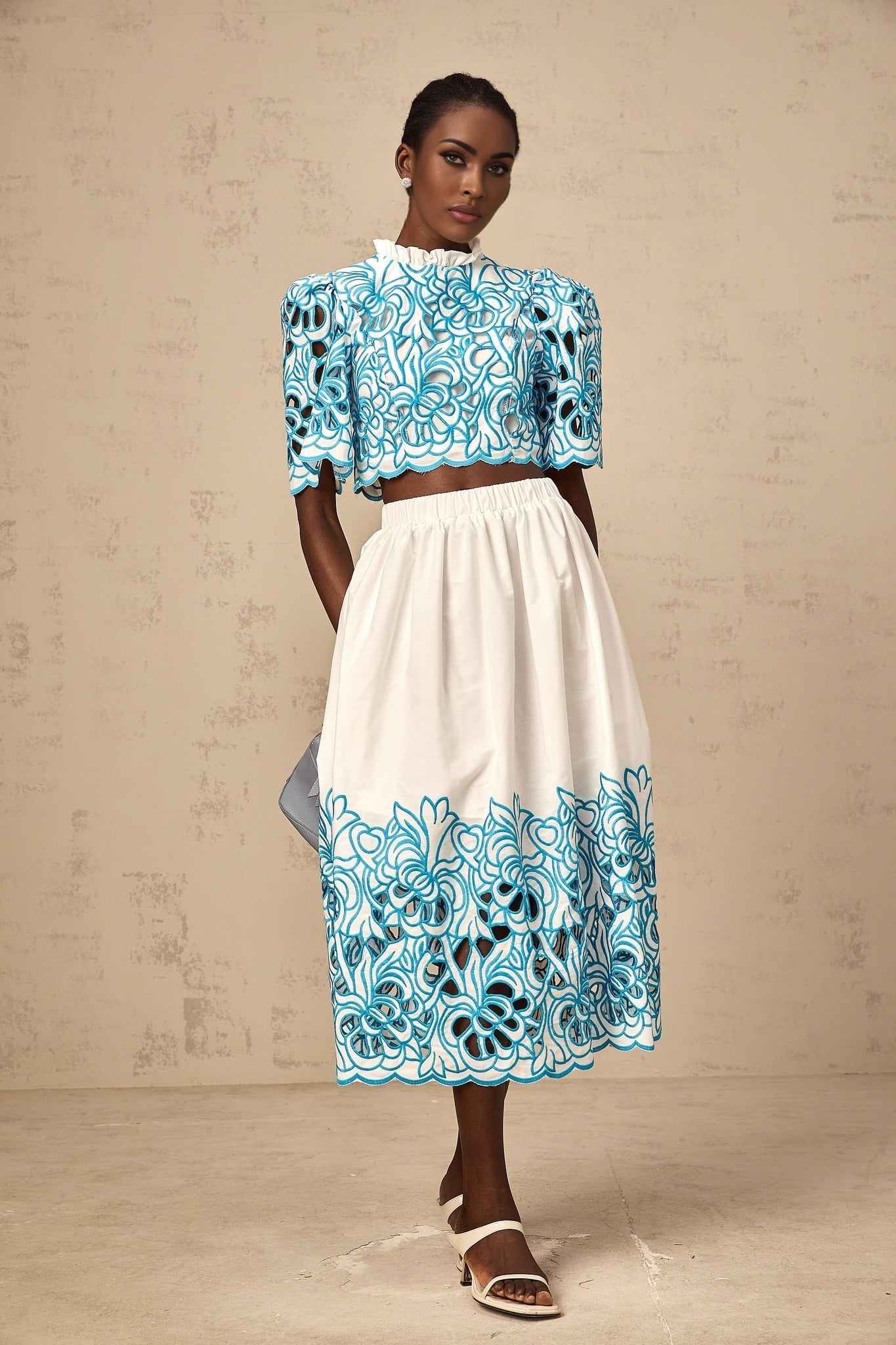 Womens two piece outfit featuring a blue embroidered top with cut out details and matching skirt