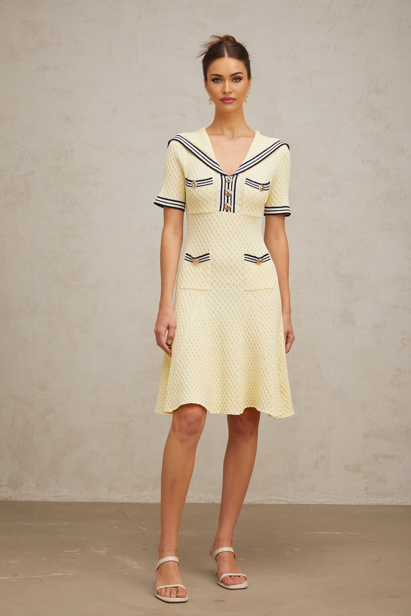 Young girl wearing a yellow knitted dress with sailor collar