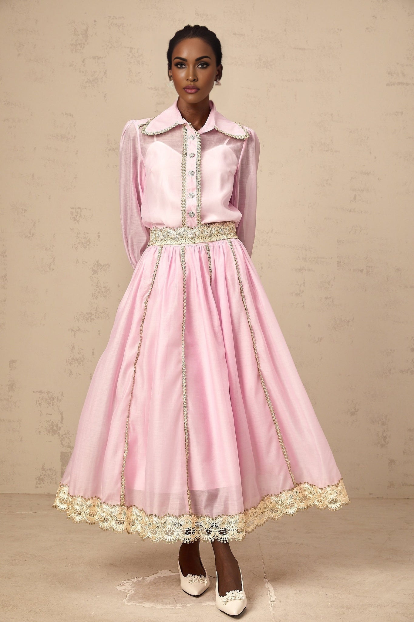Young girl wearing pink lace trimmed shirt and matching skirt set by Frida