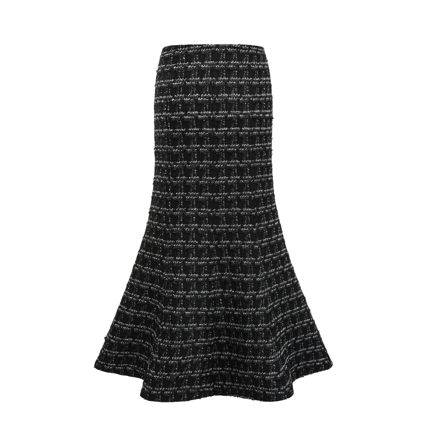 Young woman wearing a black and white checked tweed matching set consisting of a vest top and skirt standing against a plain background