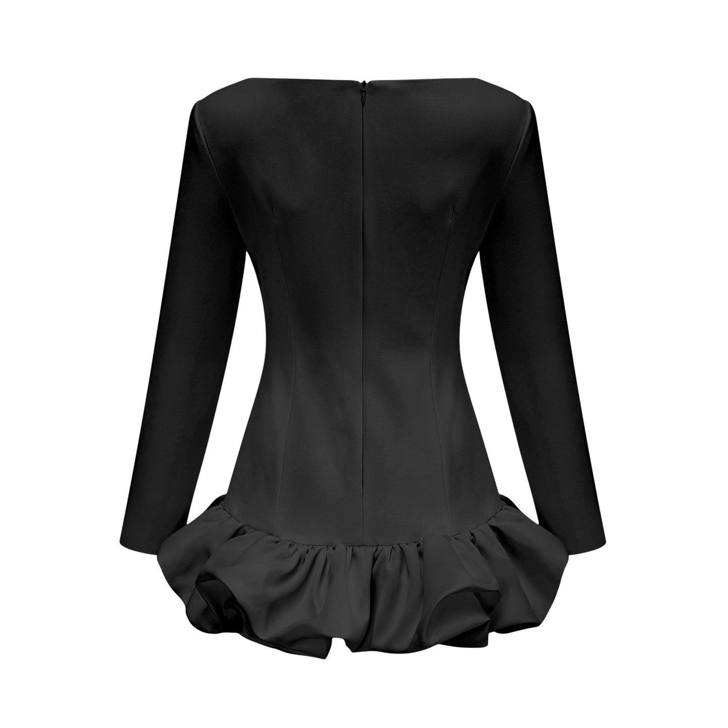 Young woman wearing a black mini dress with a bubble skirt and short sleeves standing against a plain background