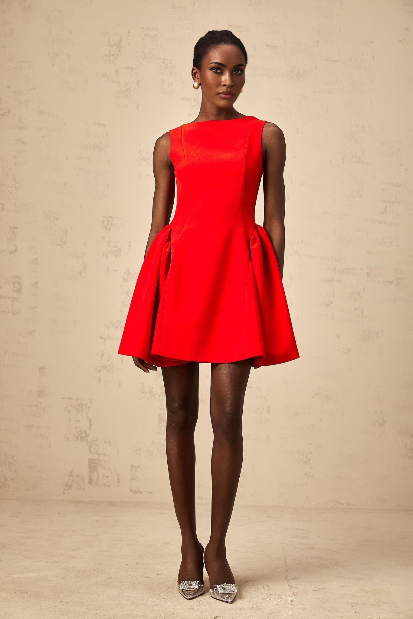 Young woman wearing a bright red sleeveless mini dress with a flared skirt