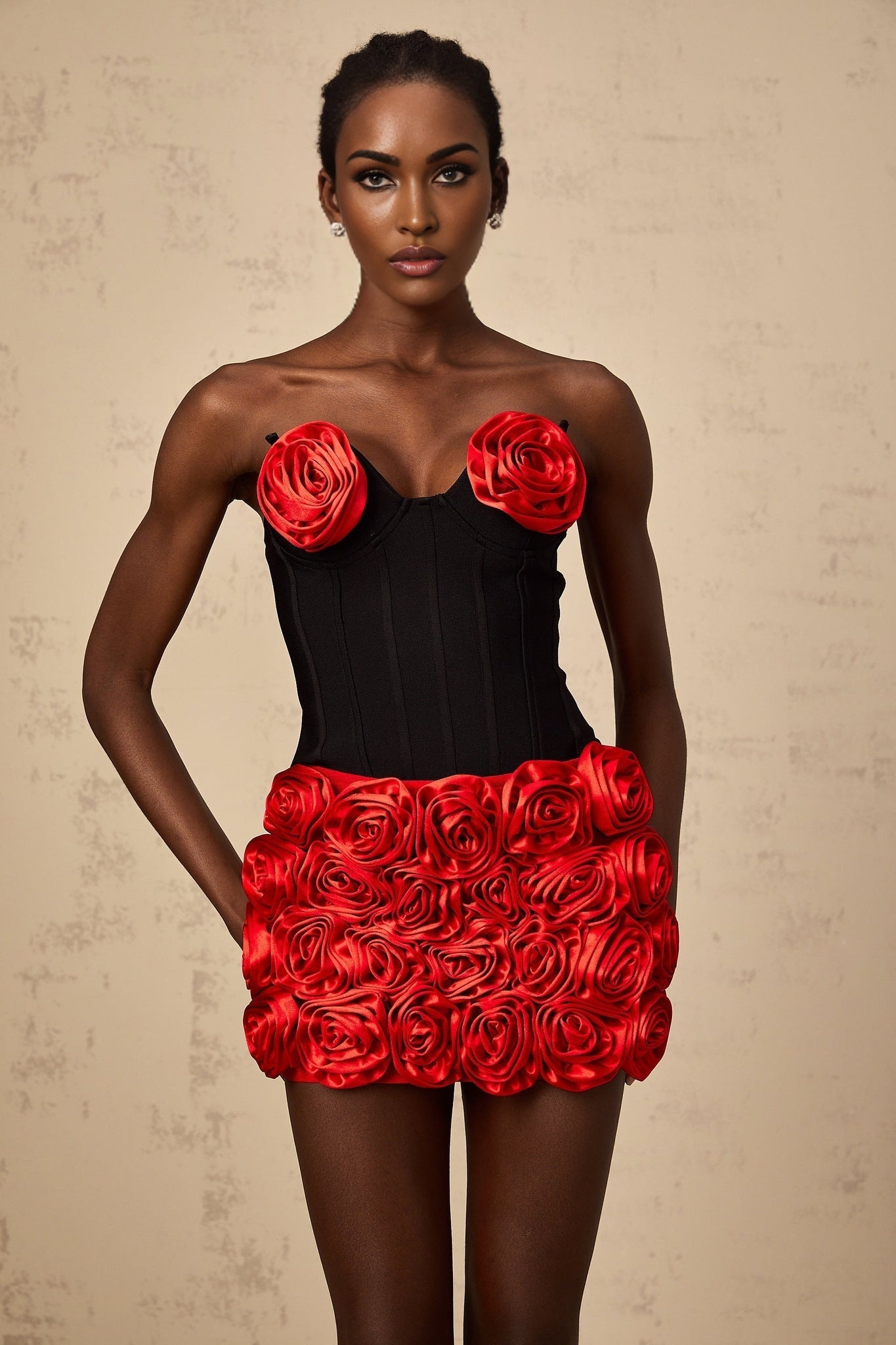 Young woman wearing a red matching set consisting of a top and skirt with rose applique details